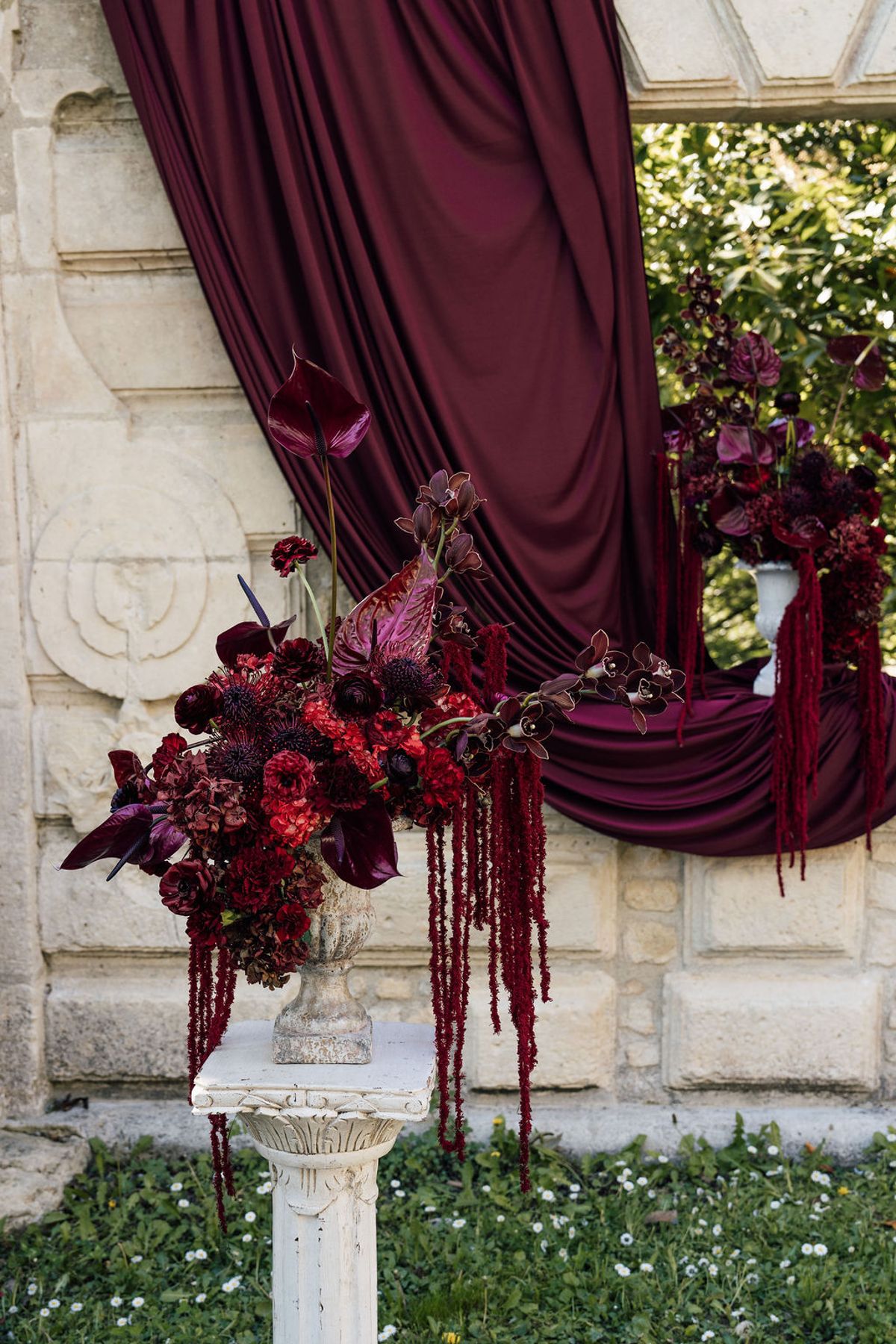 Styled shoot models Harper and Liam: the floral arrangement against the burgundy drape, Chateau de Mirambeau, spring editorial
