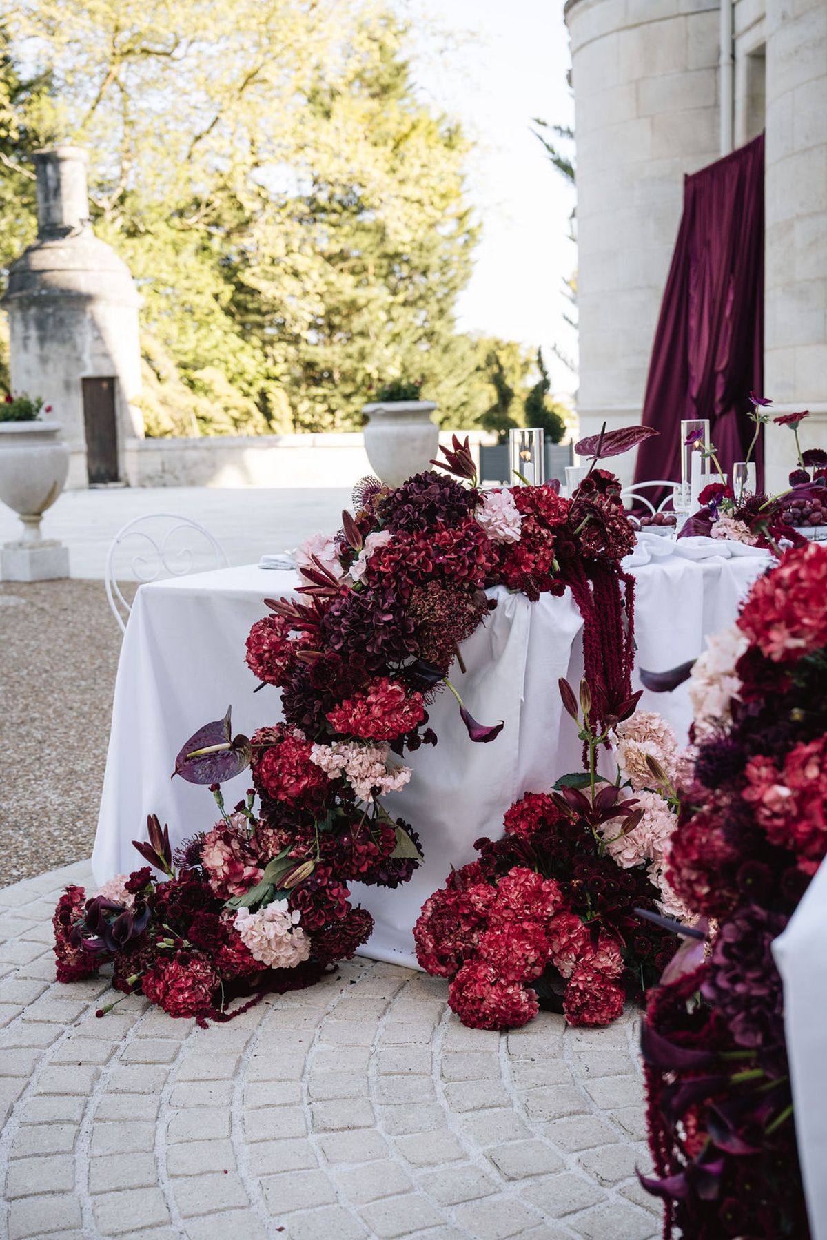 Styled shoot models Harper and Liam: the floral arch framing the reception table, Chateau de Mirambeau, spring editorial