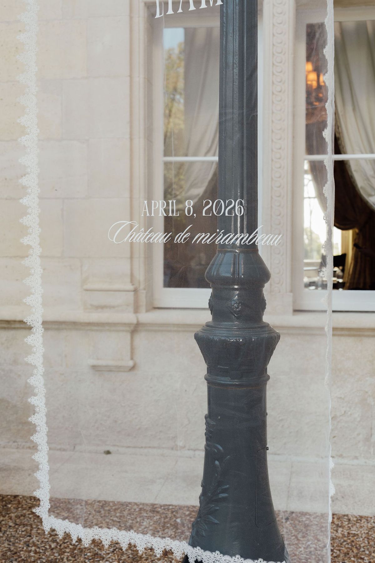 Styled shoot models Harper and Liam: signage naming the chateau against the stone facade, Chateau de Mirambeau, spring editorial
