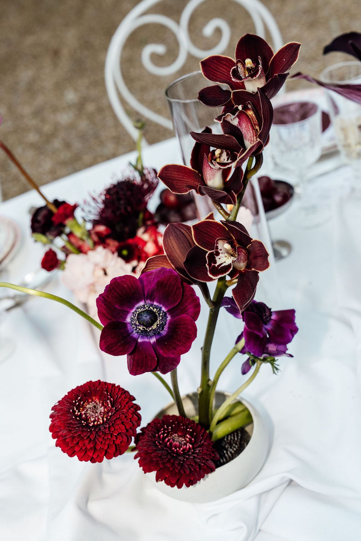 Styled shoot models Harper and Liam: a macro study of burgundy anemones on the table, Chateau de Mirambeau, spring editorial