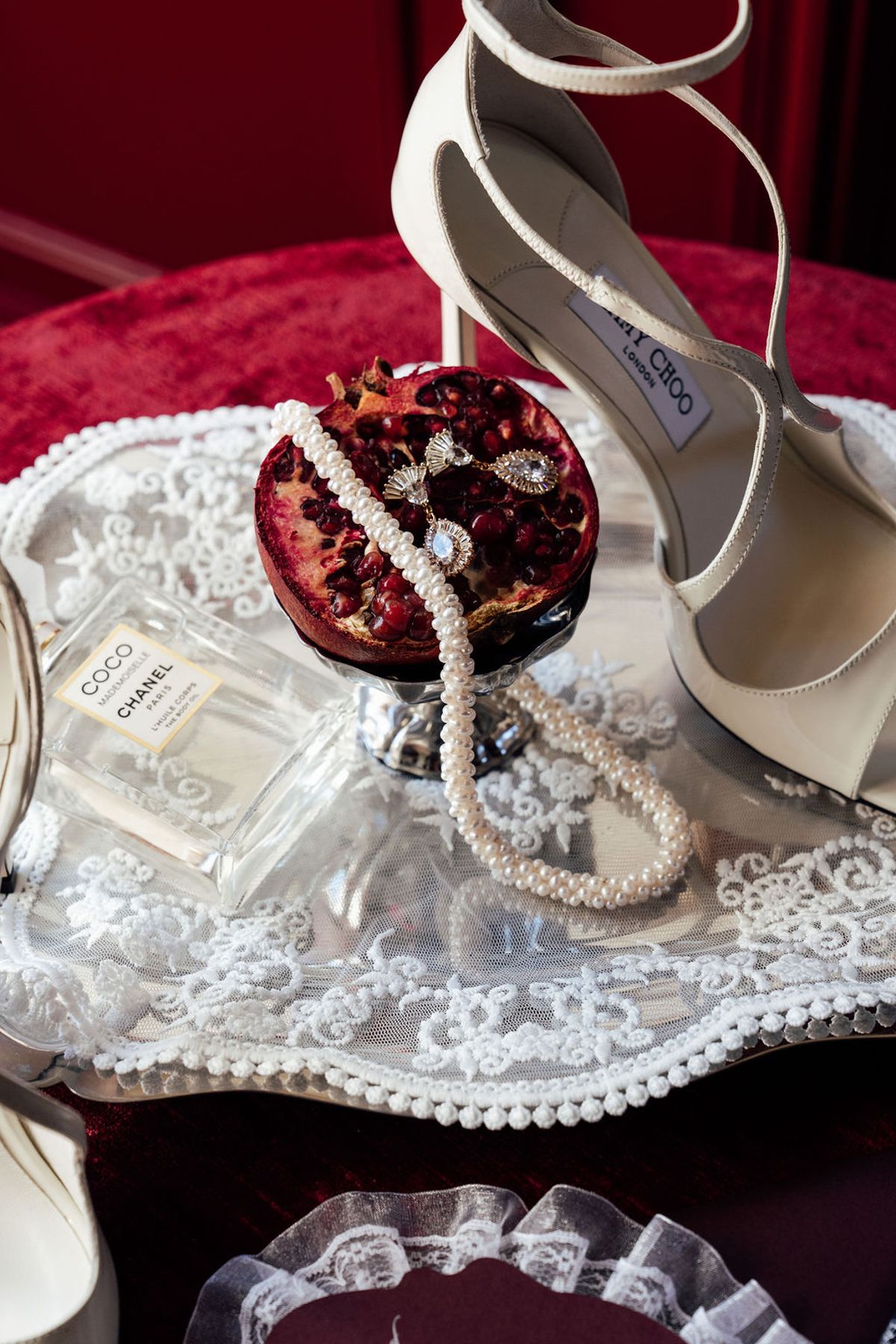 Styled shoot models Harper and Liam: Chanel perfume, ivory heels, and a pomegranate-and-pearl detail on a mirrored tray, Chateau de Mirambeau, spring editorial