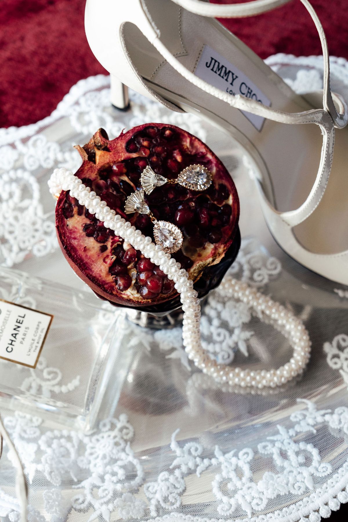 Styled shoot models Harper and Liam: pomegranate, pearl strand, and a lace-trimmed shoe on the tray, Chateau de Mirambeau, spring editorial