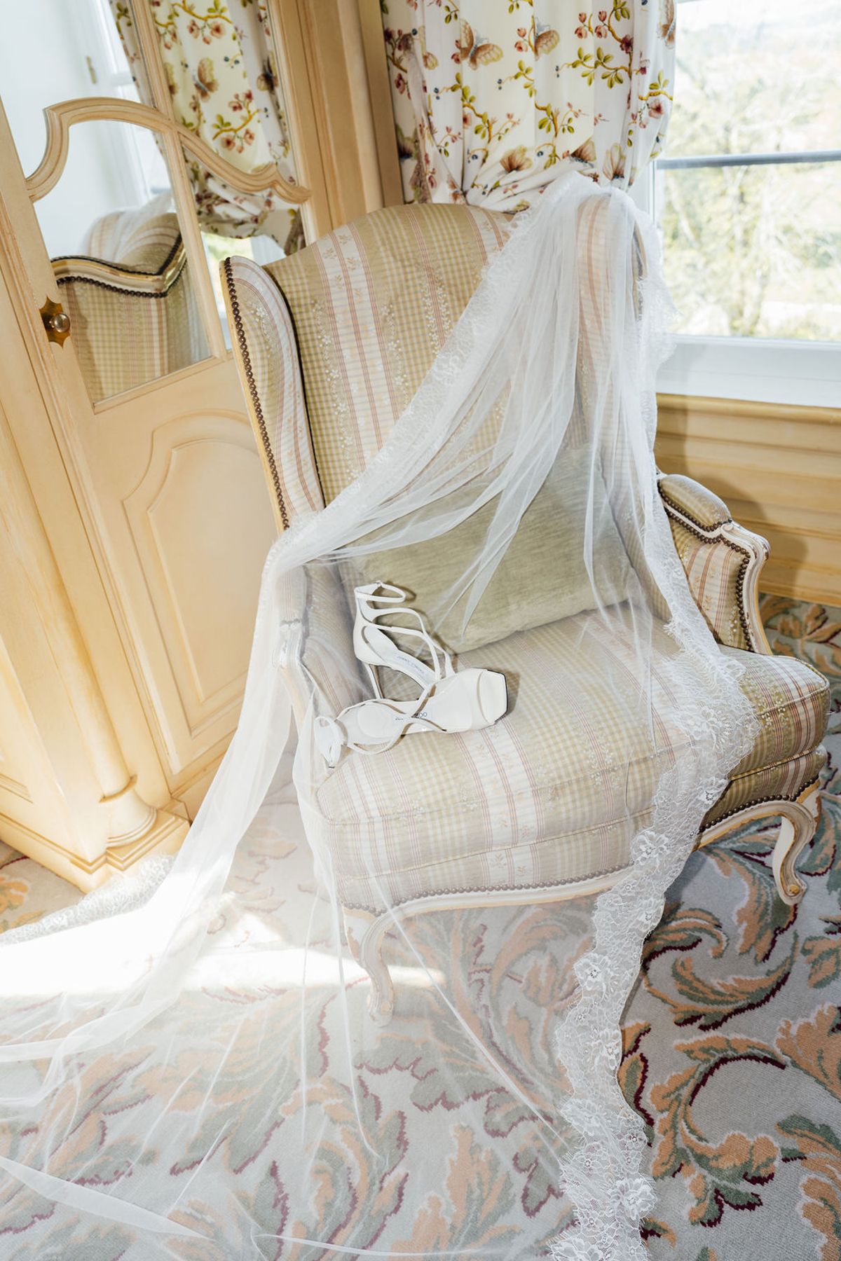 Styled shoot models Harper and Liam: the gown and heels laid across a bedroom chair, Chateau de Mirambeau, spring editorial