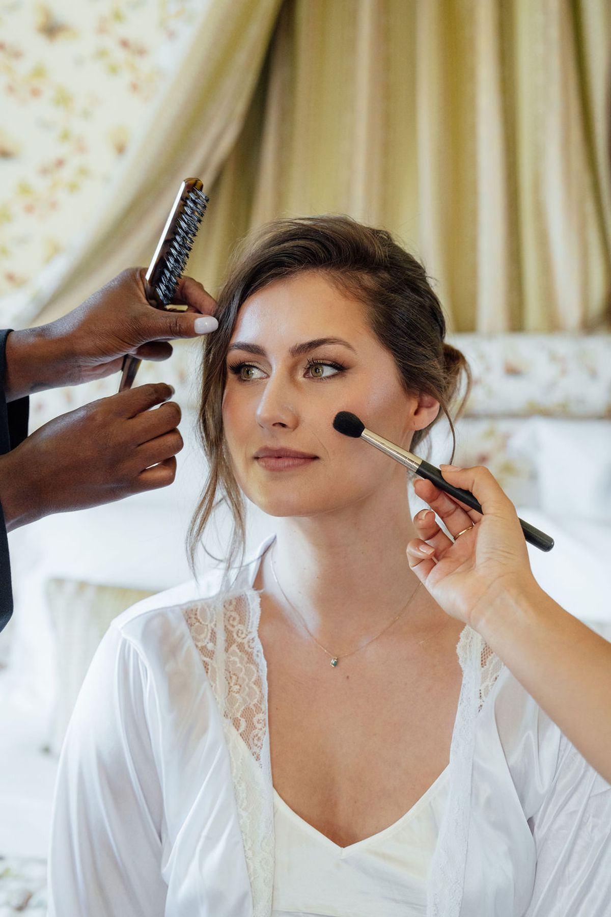 Styled shoot models Harper and Liam: the bride having her makeup applied, Chateau de Mirambeau, spring editorial
