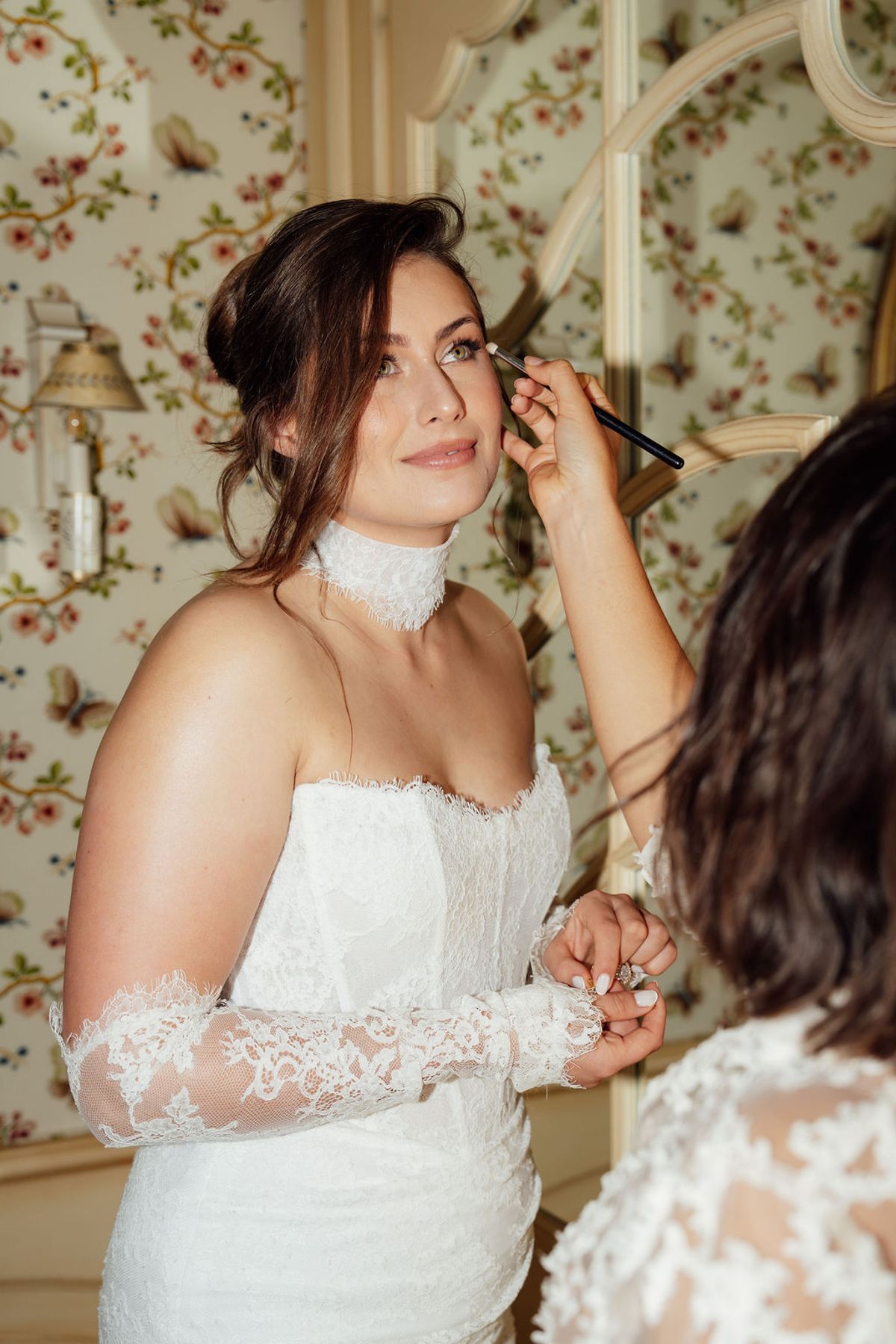 Styled shoot models Harper and Liam: the bride's hair styled, lace sleeve visible, Chateau de Mirambeau, spring editorial