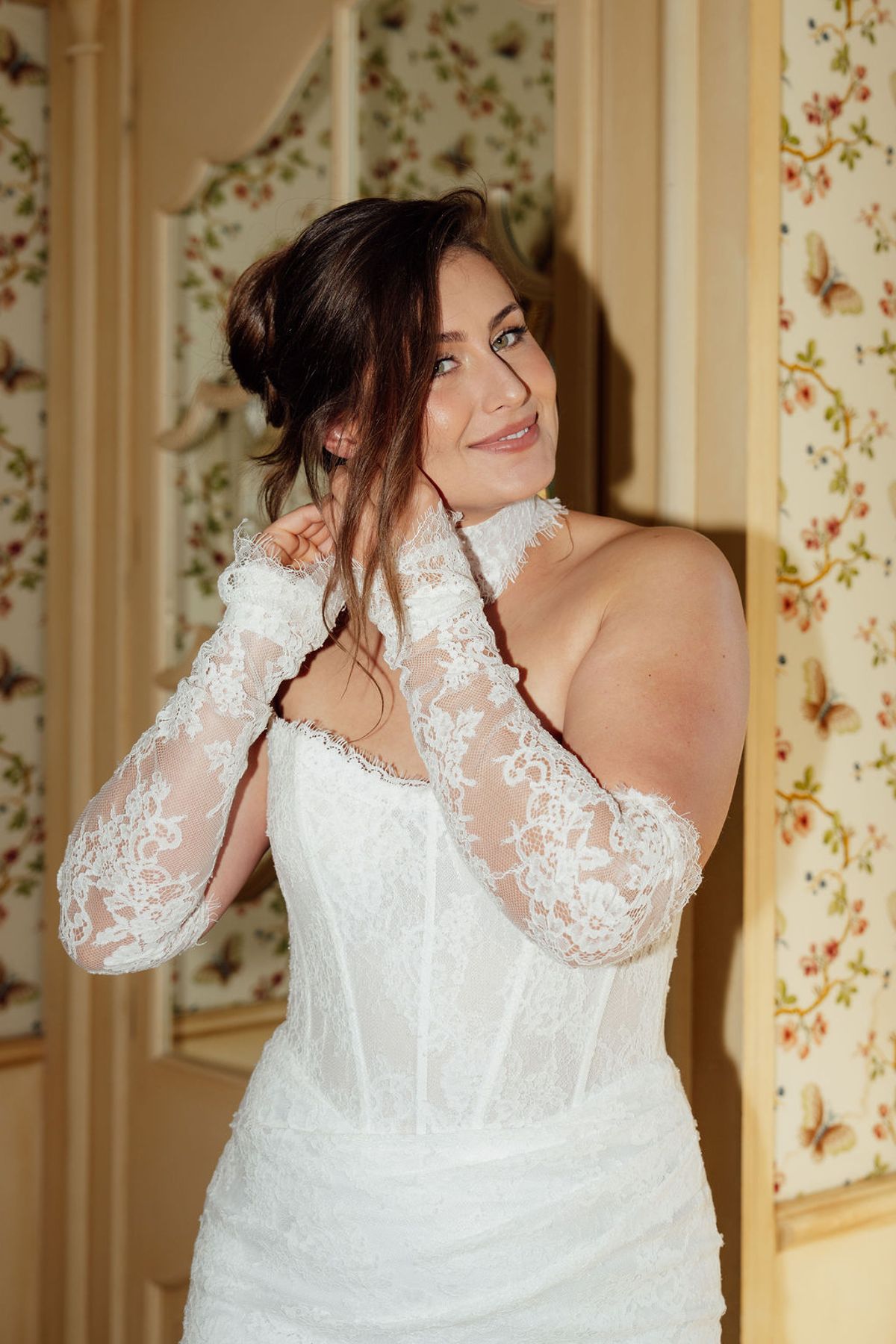 Styled shoot models Harper and Liam: a close view of the bride's lace sleeve and open back, Chateau de Mirambeau, spring editorial