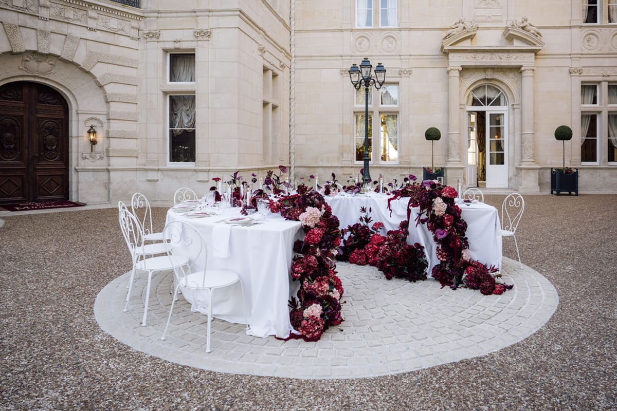 Styled shoot models Harper and Liam: the round reception table set in the chateau courtyard, Chateau de Mirambeau, spring editorial