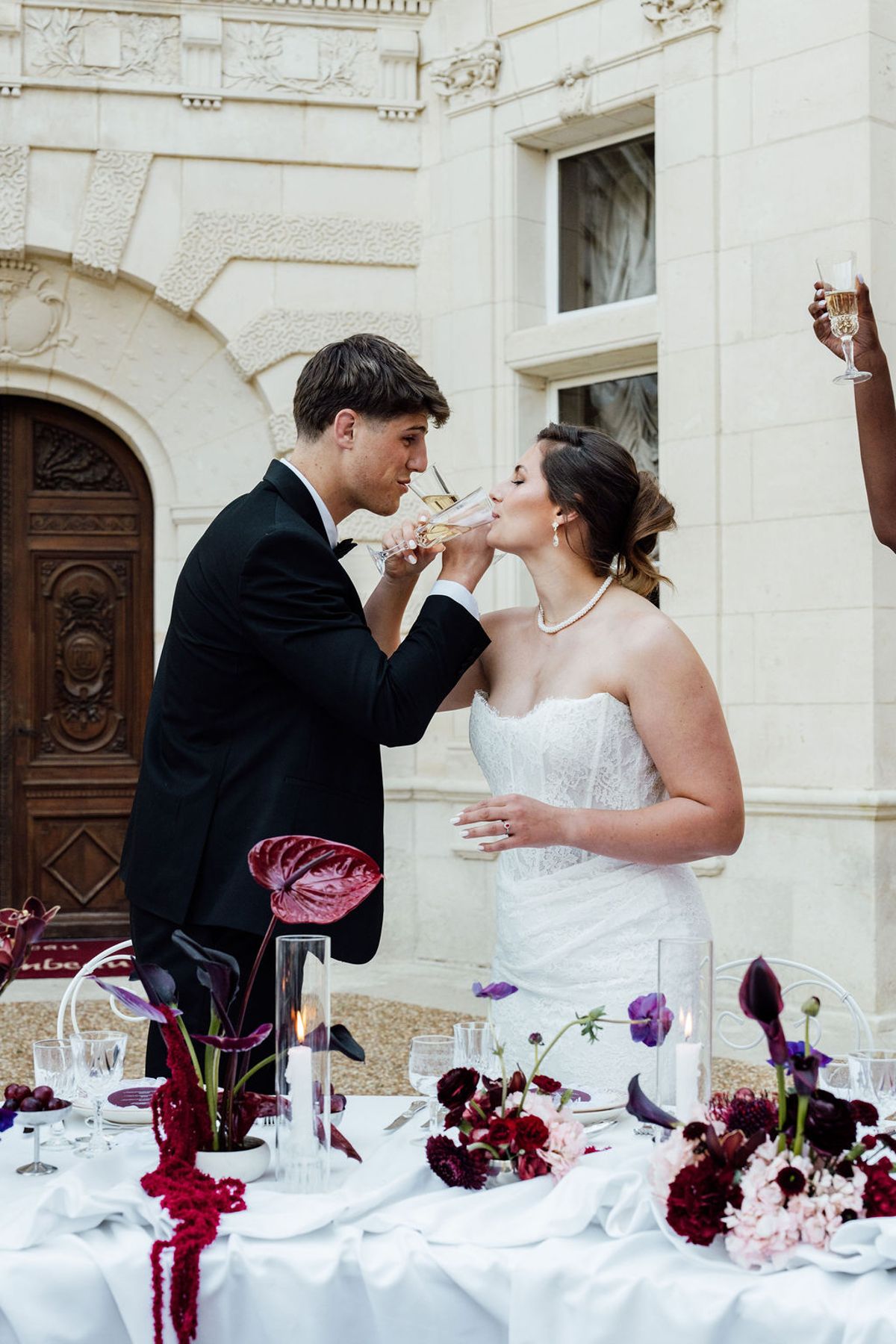 Styled shoot models Harper and Liam: a candid moment as the groom feeds the bride at the table, Chateau de Mirambeau, spring editorial