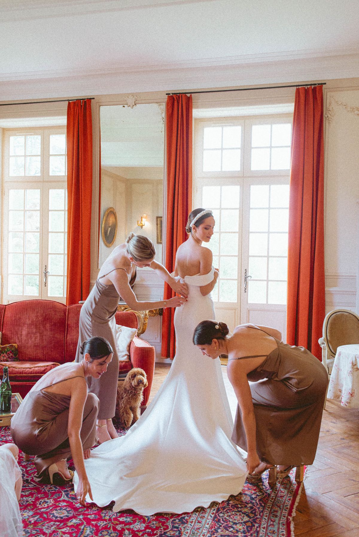 Bridesmaids helping bride dress at Chateau de Campet