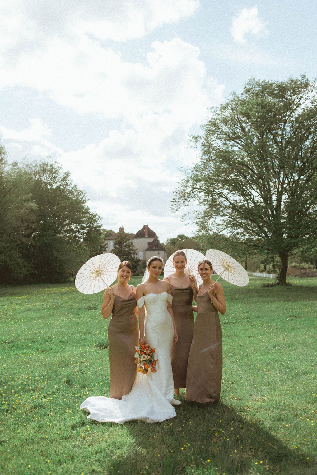 Bride and bridesmaids with parasols at Chateau de Campet