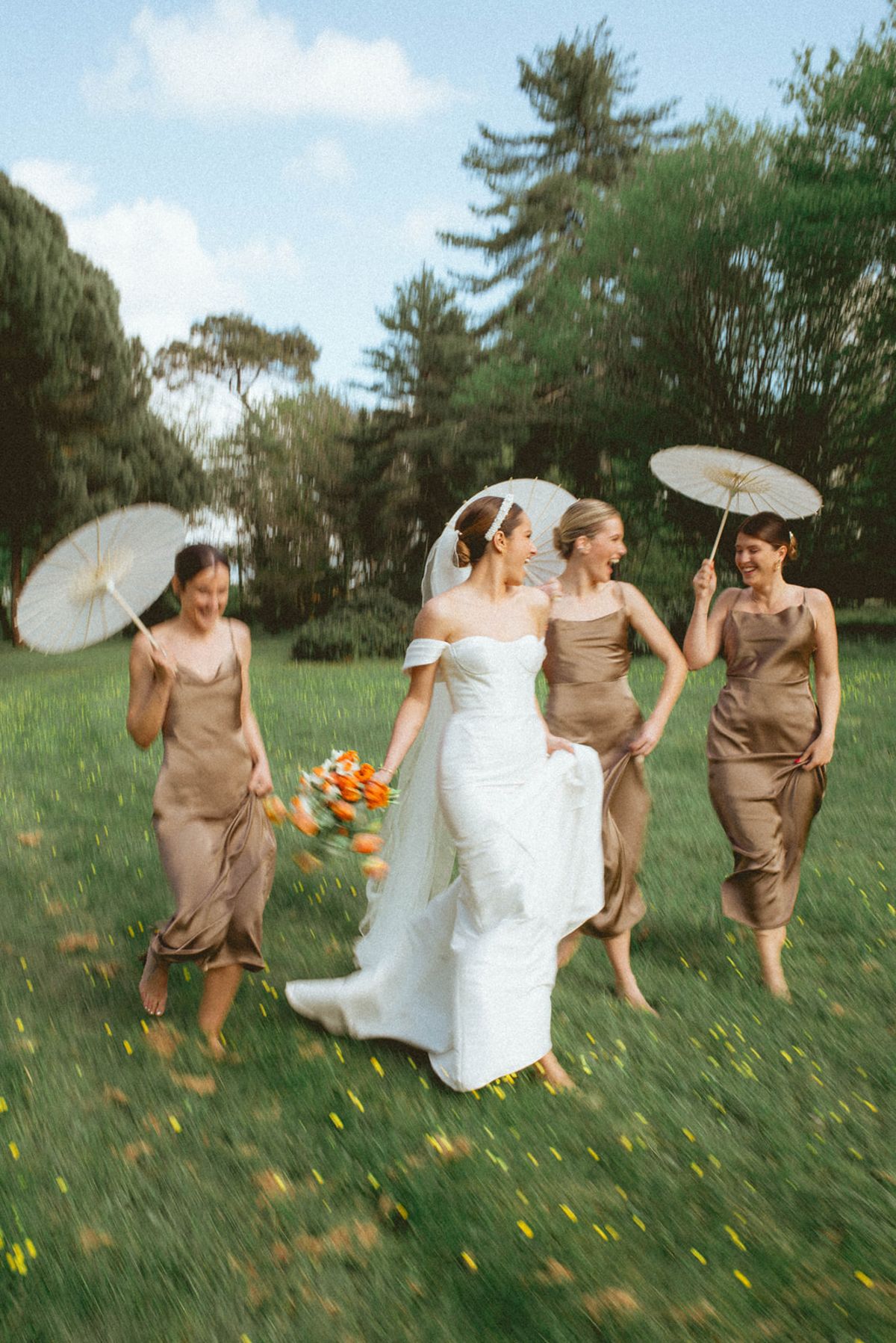 Bride and bridesmaids walking with parasols at Chateau de Campet