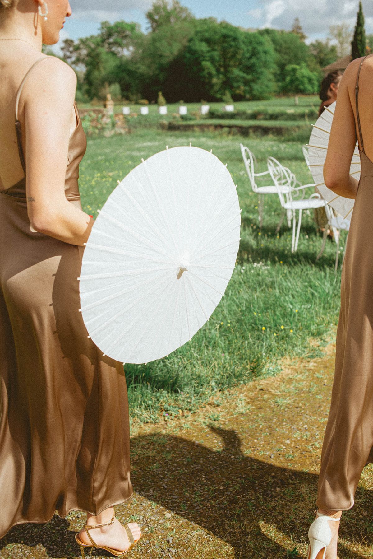Bridesmaids with parasol from behind at Chateau de Campet
