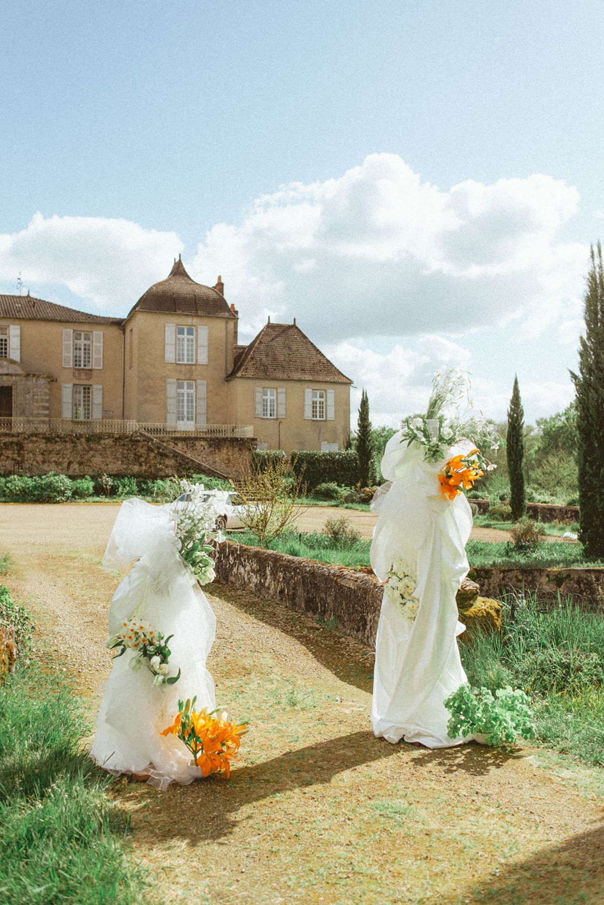 Ceremony arch towers with orange flowers at Chateau de Campet