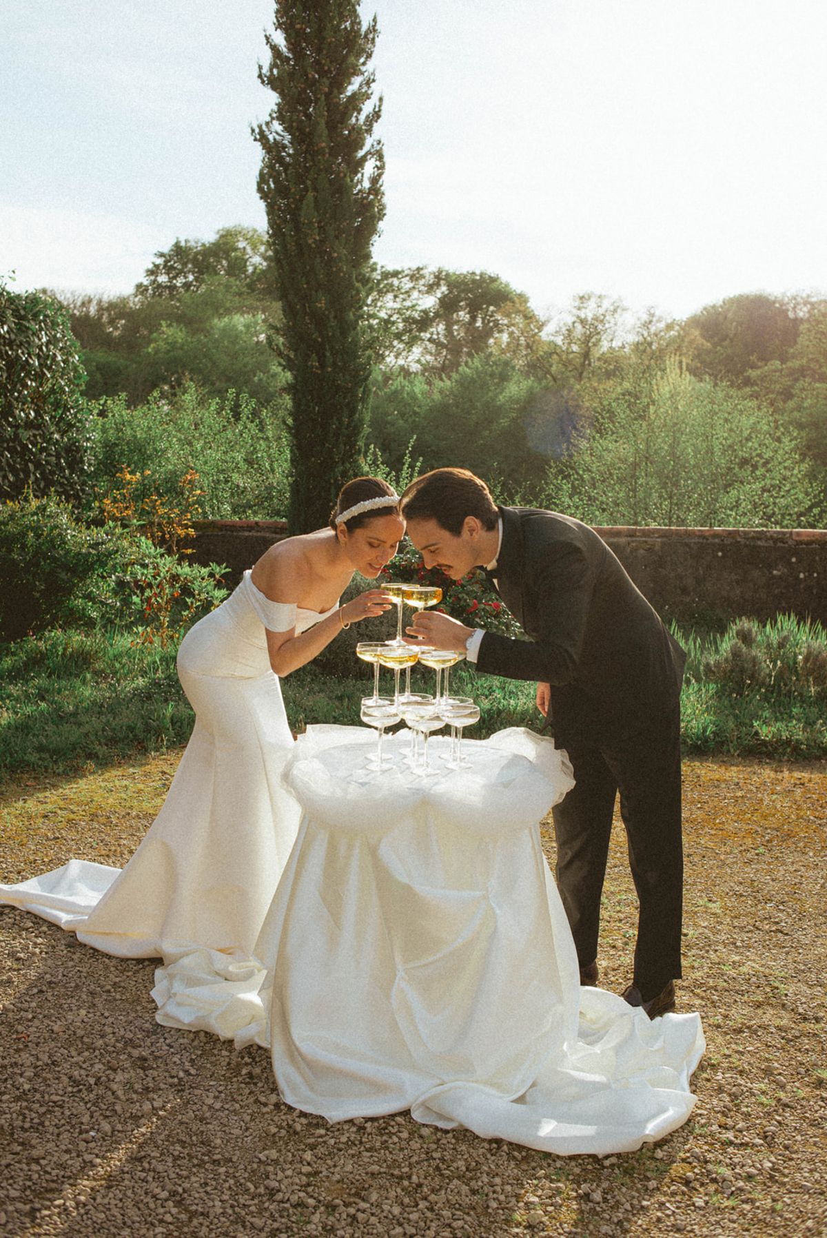 Couple drinking from champagne tower at golden hour at Chateau de Campet