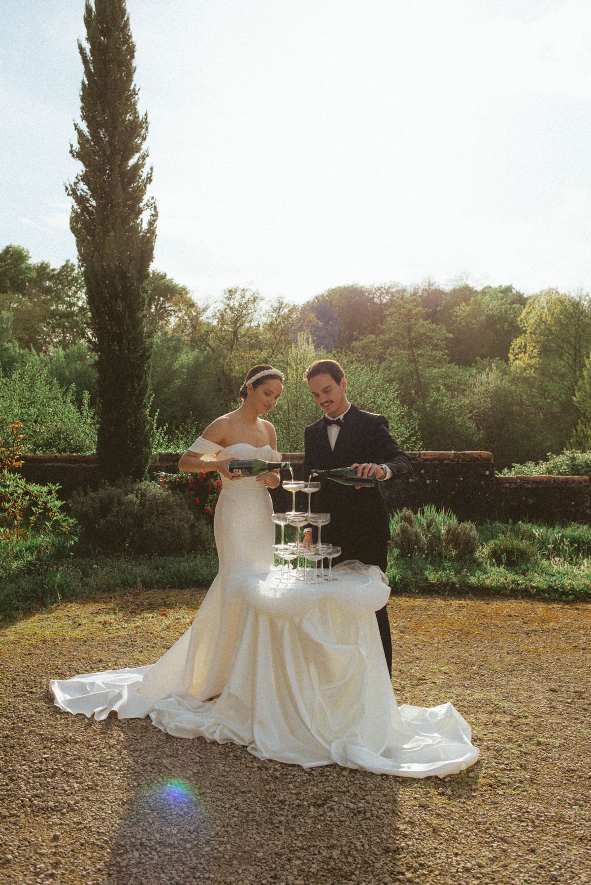 Couple pouring champagne tower at Chateau de Campet