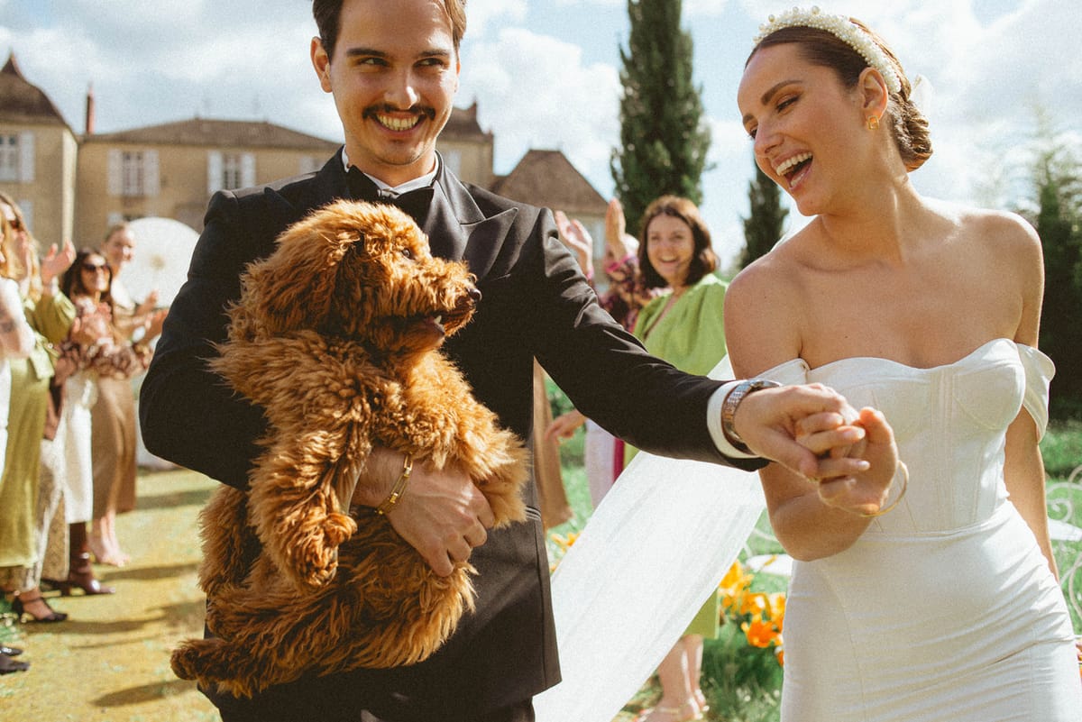 Couple with dog walking aisle at Chateau de Campet