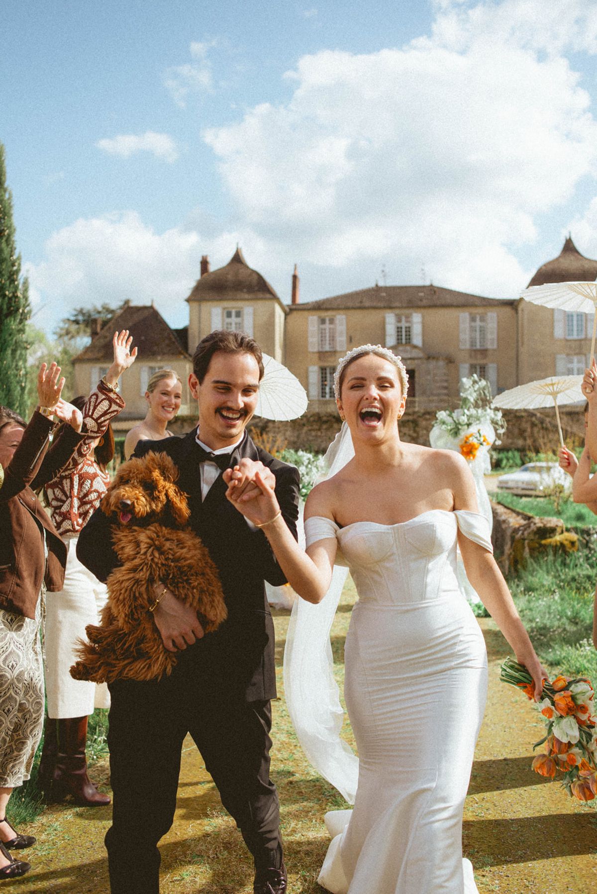 Couple laughing with dog at ceremony at Chateau de Campet