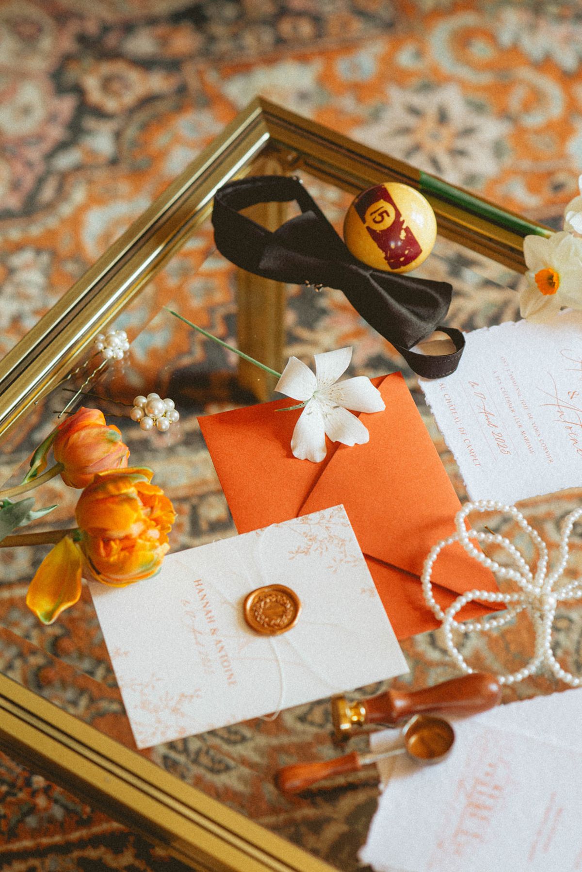 Orange-palette stationery flat lay at Chateau de Campet