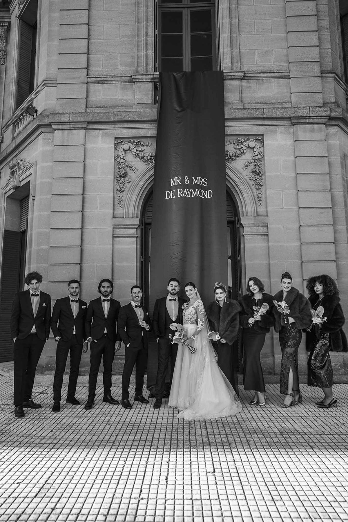 Black and white bridal party portrait at Chateau du Terral facade