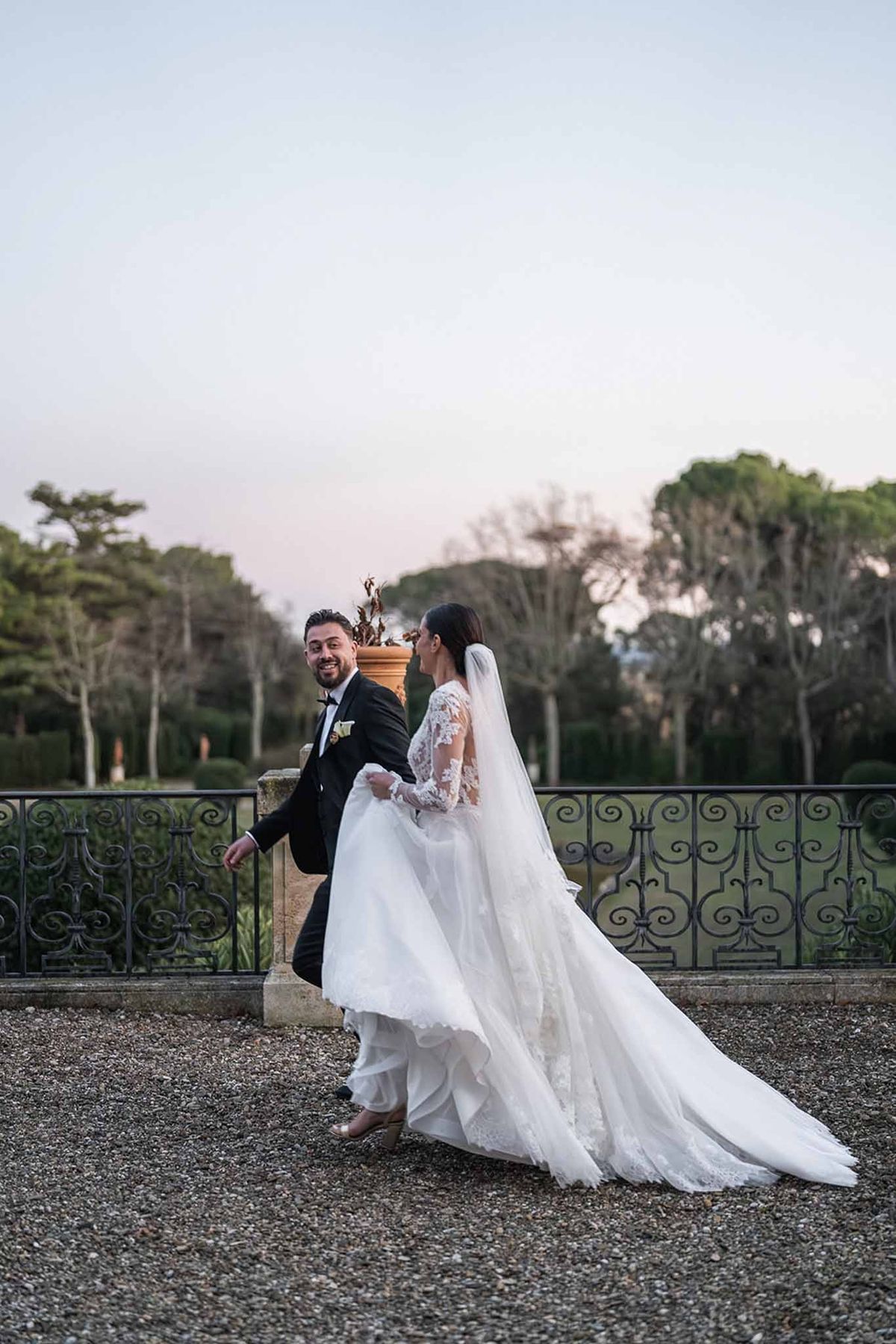 Couple running hand in hand on terrace at dusk at Chateau du Terral