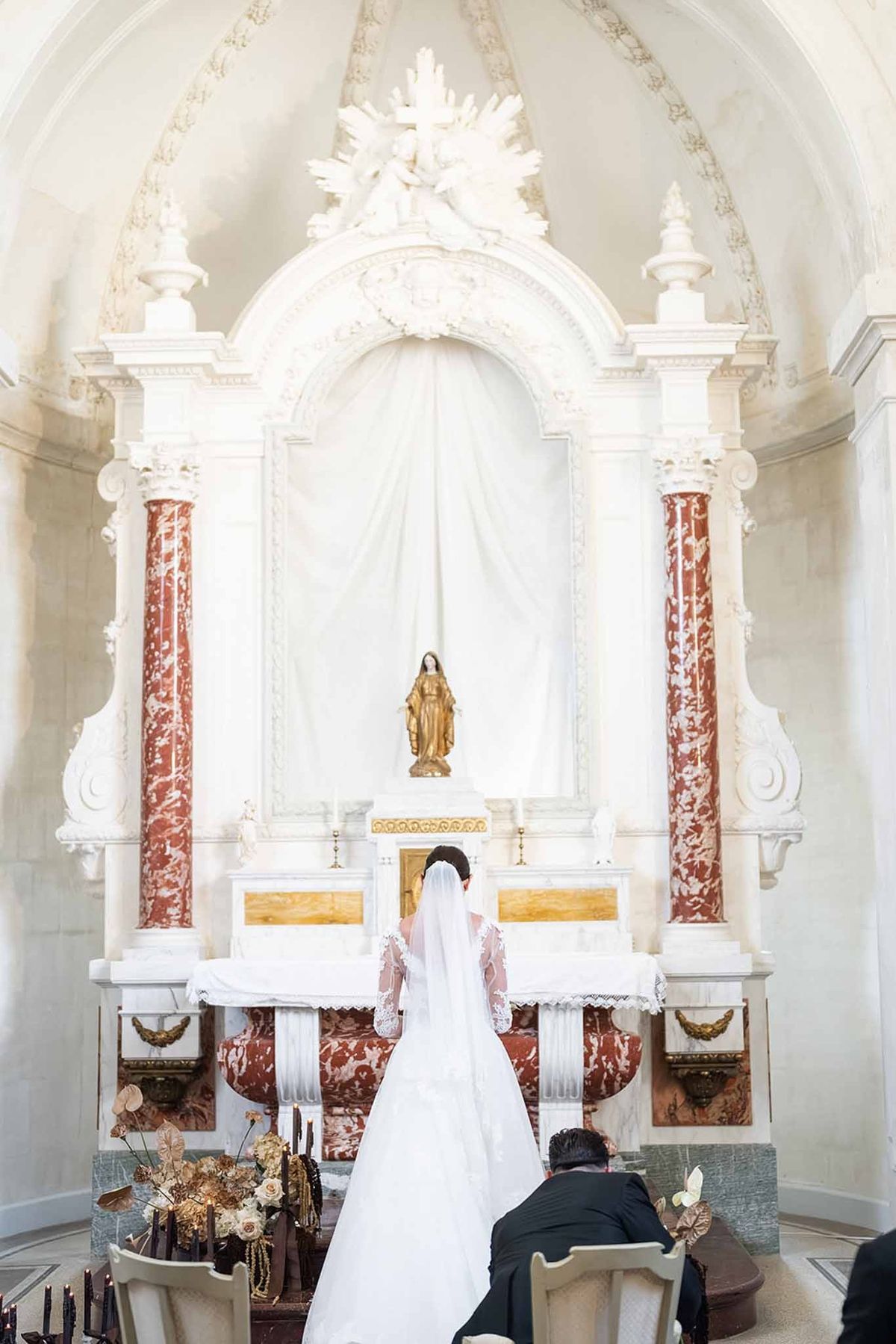 Couple at baroque chapel altar during ceremony at Chateau du Terral