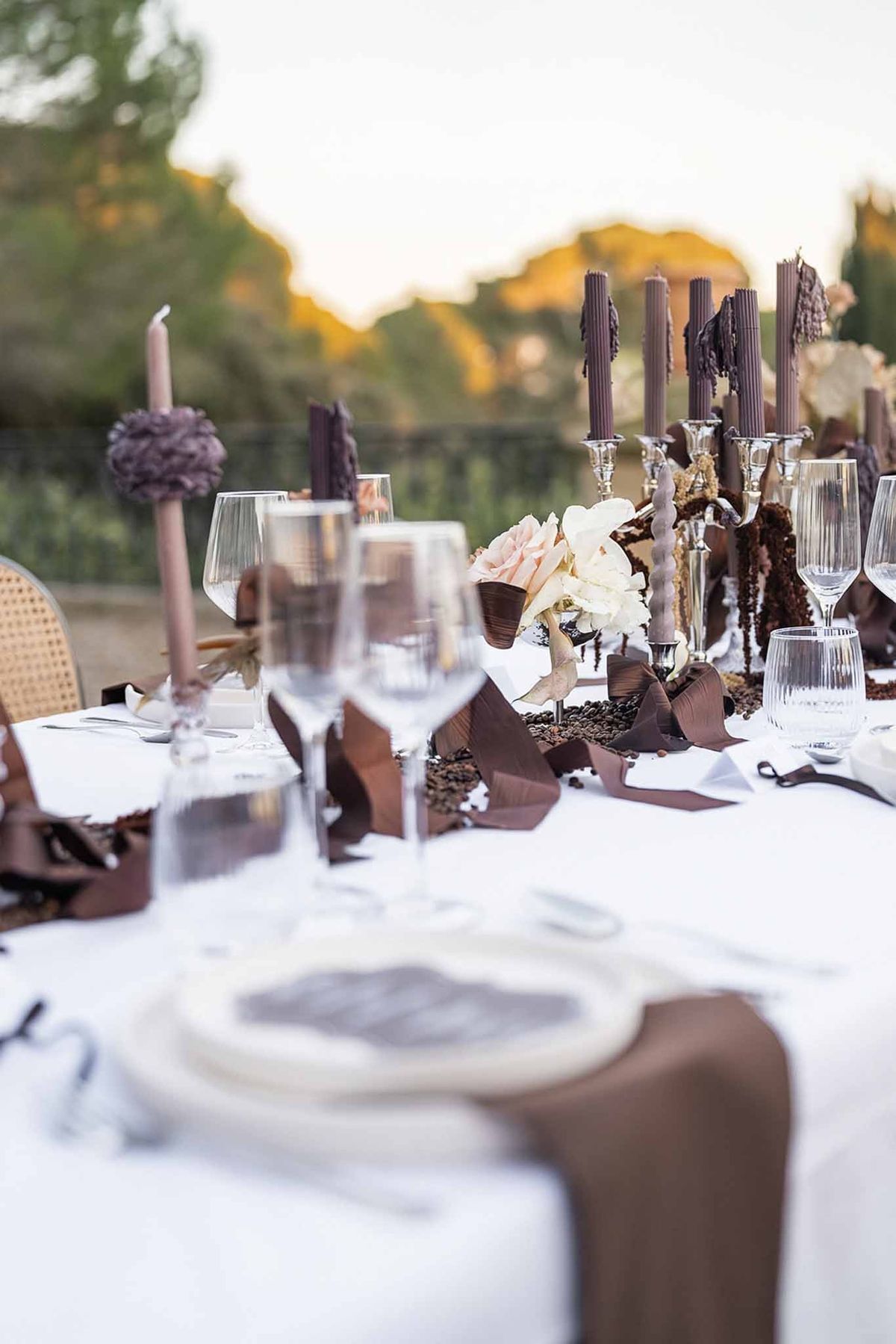 Reception table with dark candles and dried floral centrepiece at Chateau du Terral