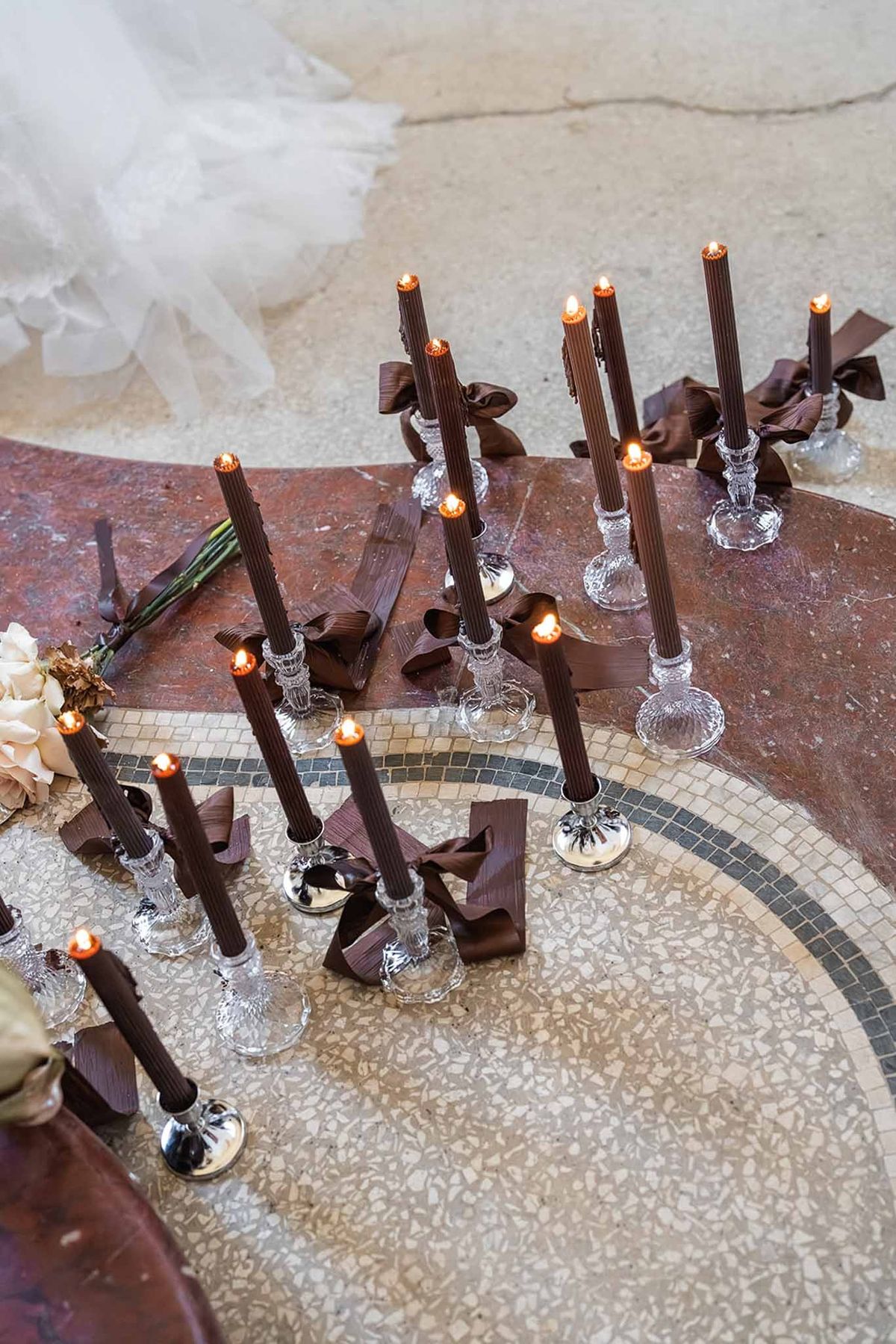 Dark tapered candles on mosaic floor at Chateau du Terral ceremony