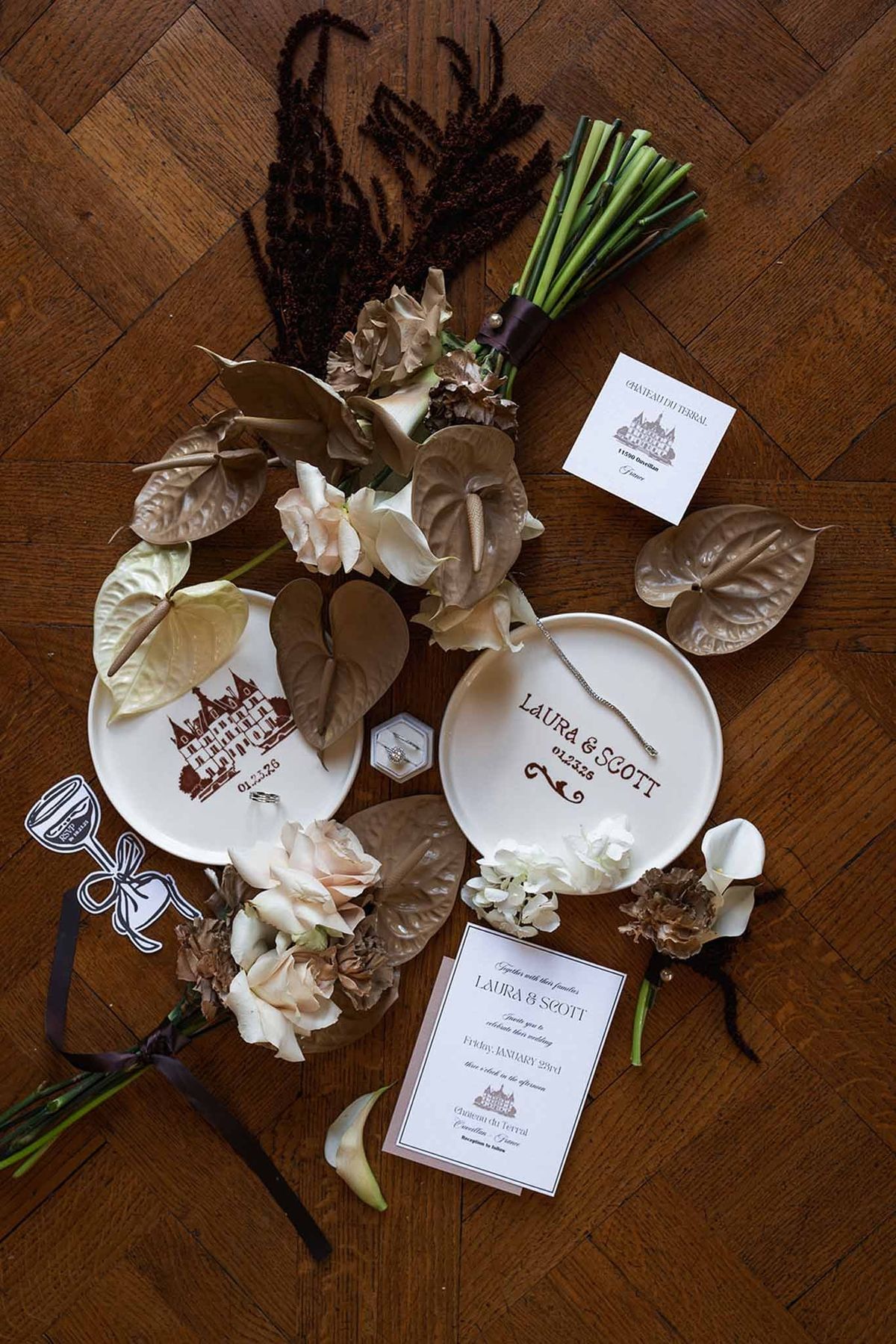 Wedding flatlay with bouquet invitation and custom plates at Chateau du Terral