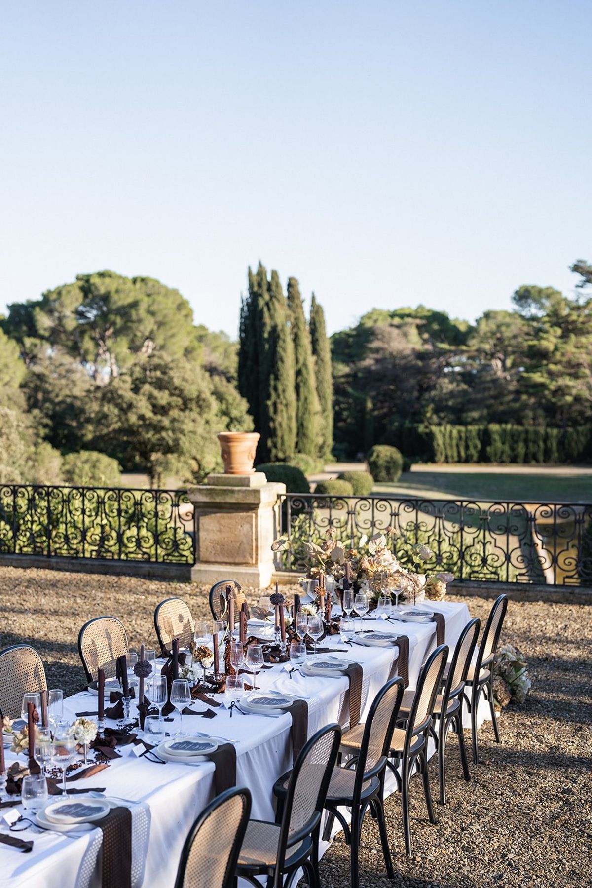 Long reception table set on chateau terrace with cypress garden backdrop at Chateau du Terral