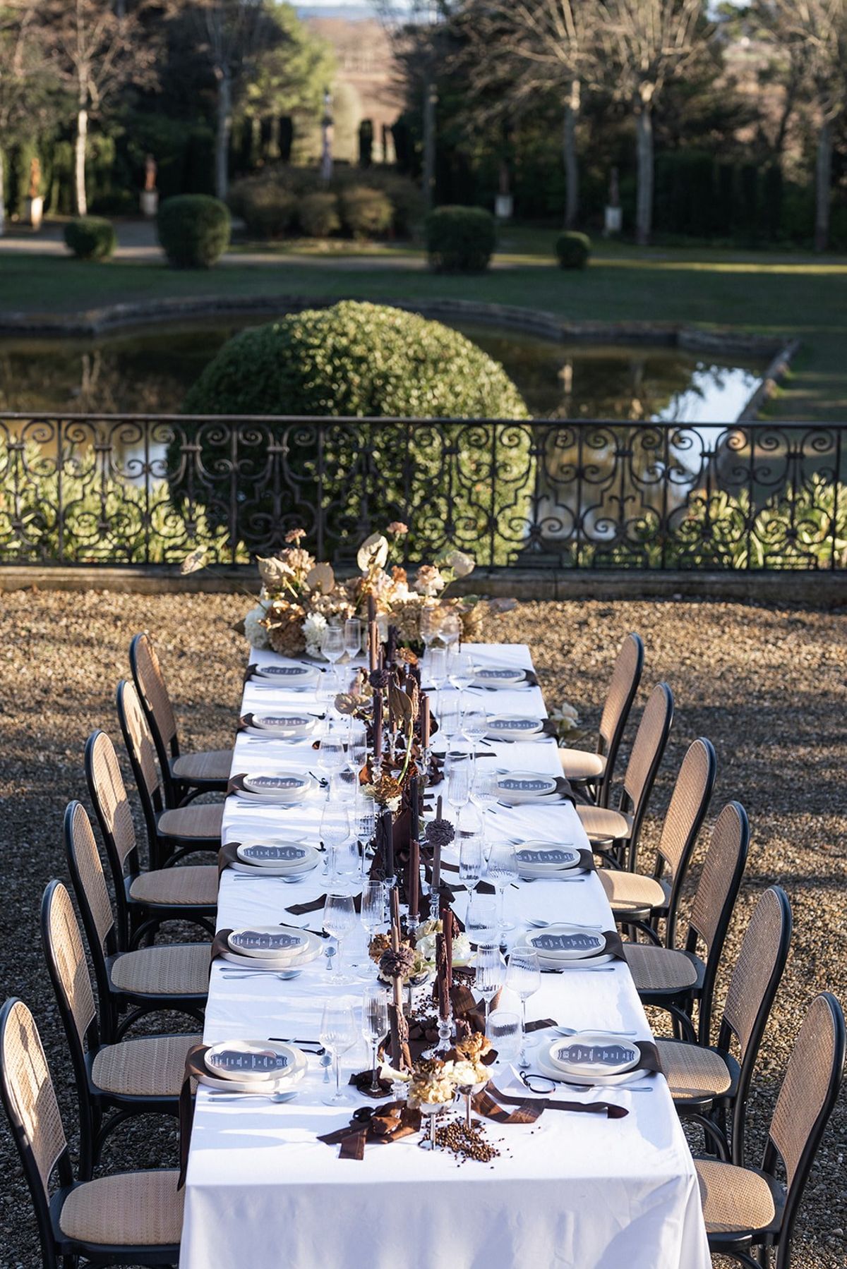 Reception table with brown candles overlooking ornamental pond at Chateau du Terral