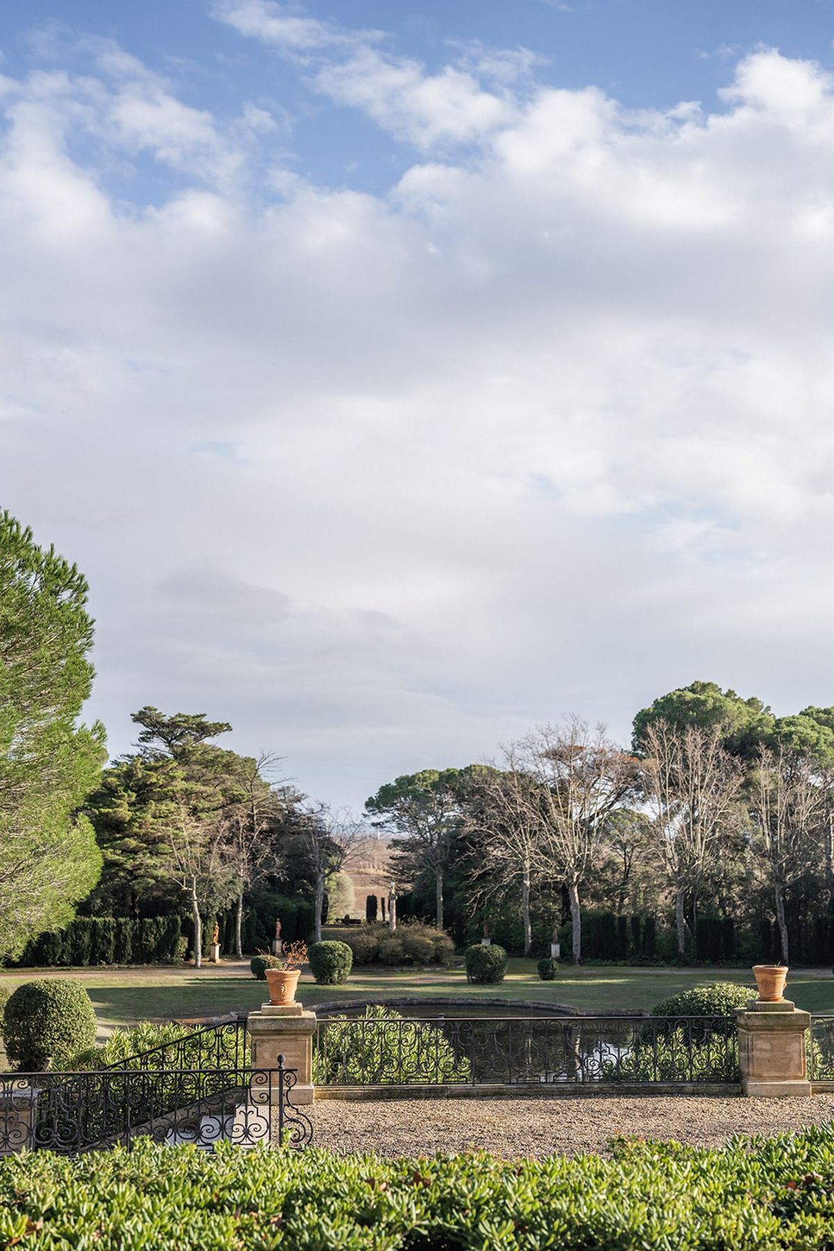 Formal garden view with ornamental pond and stone balustrade at Chateau du Terral