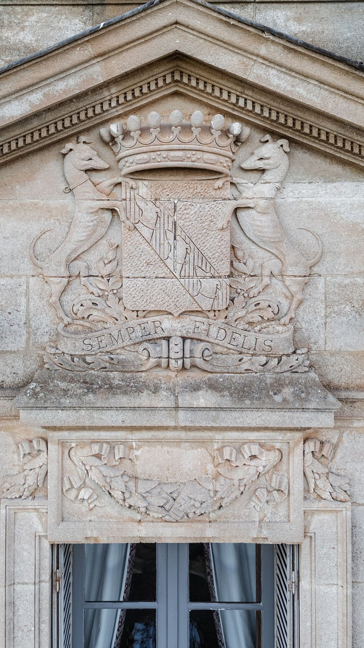 Carved stone family crest above chateau window at Chateau du Terral