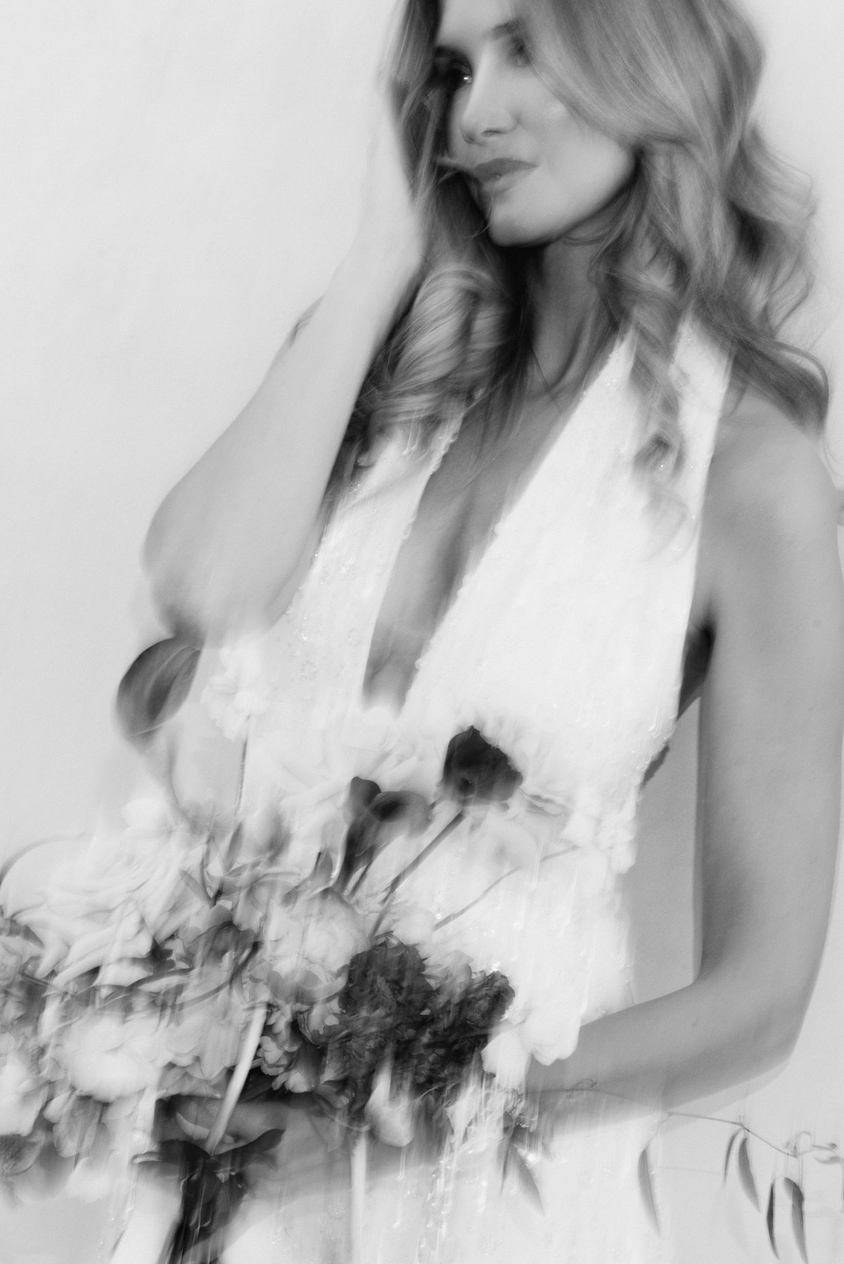 Black and white motion-blurred portrait of the bride holding her bouquet