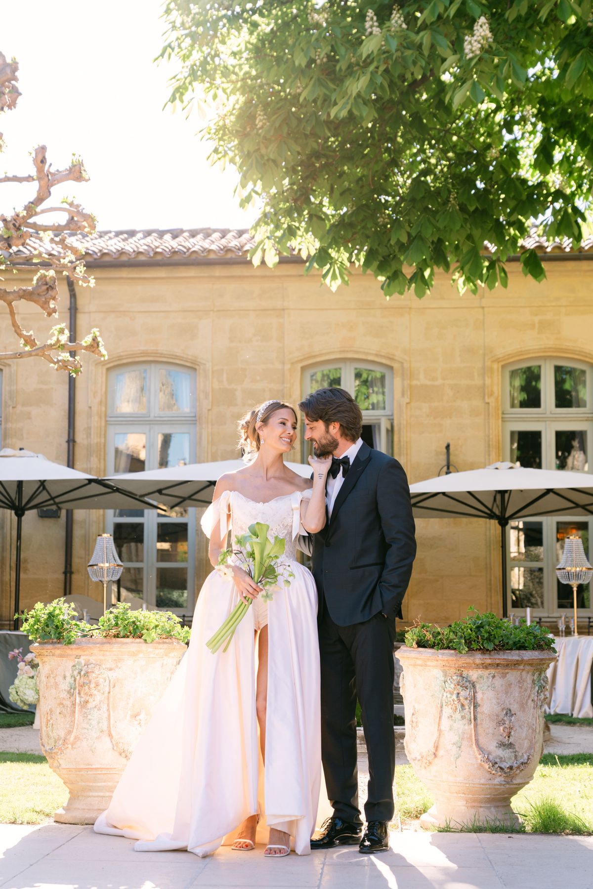 Couple standing together beneath a tree in the garden courtyard