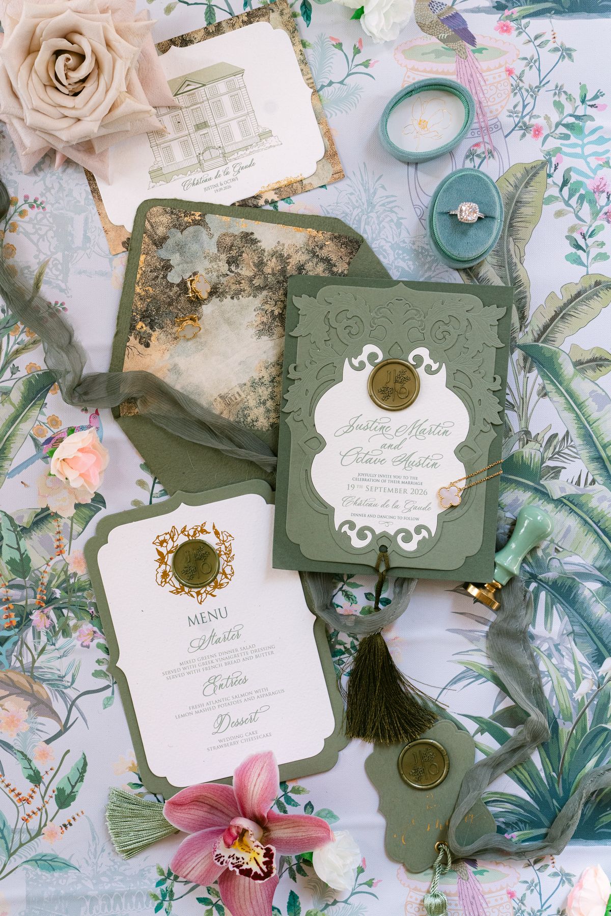Invitation suite in sage green with a gold wax seal, menu card, rose and rings
