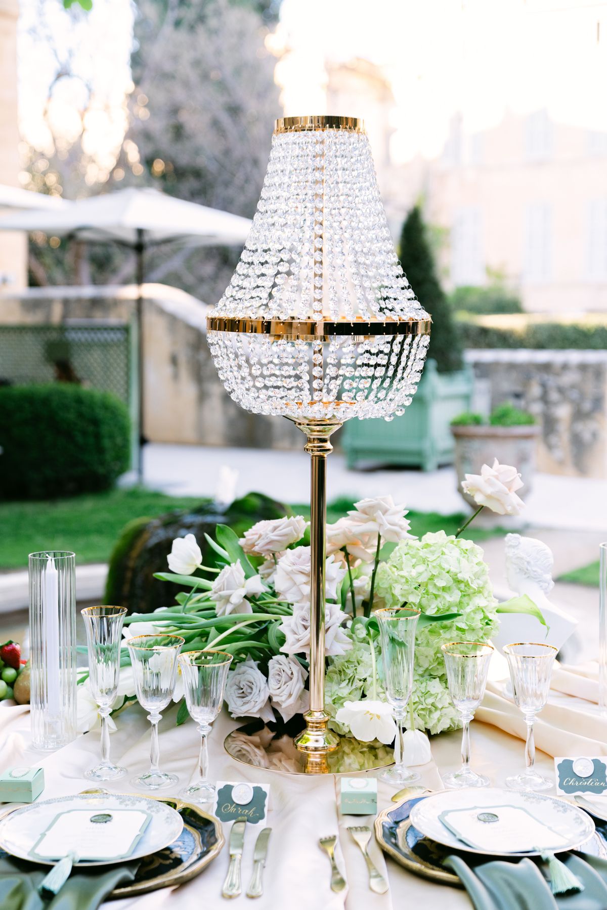 Outdoor tablescape with a crystal lamp centrepiece, tulips and hydrangea