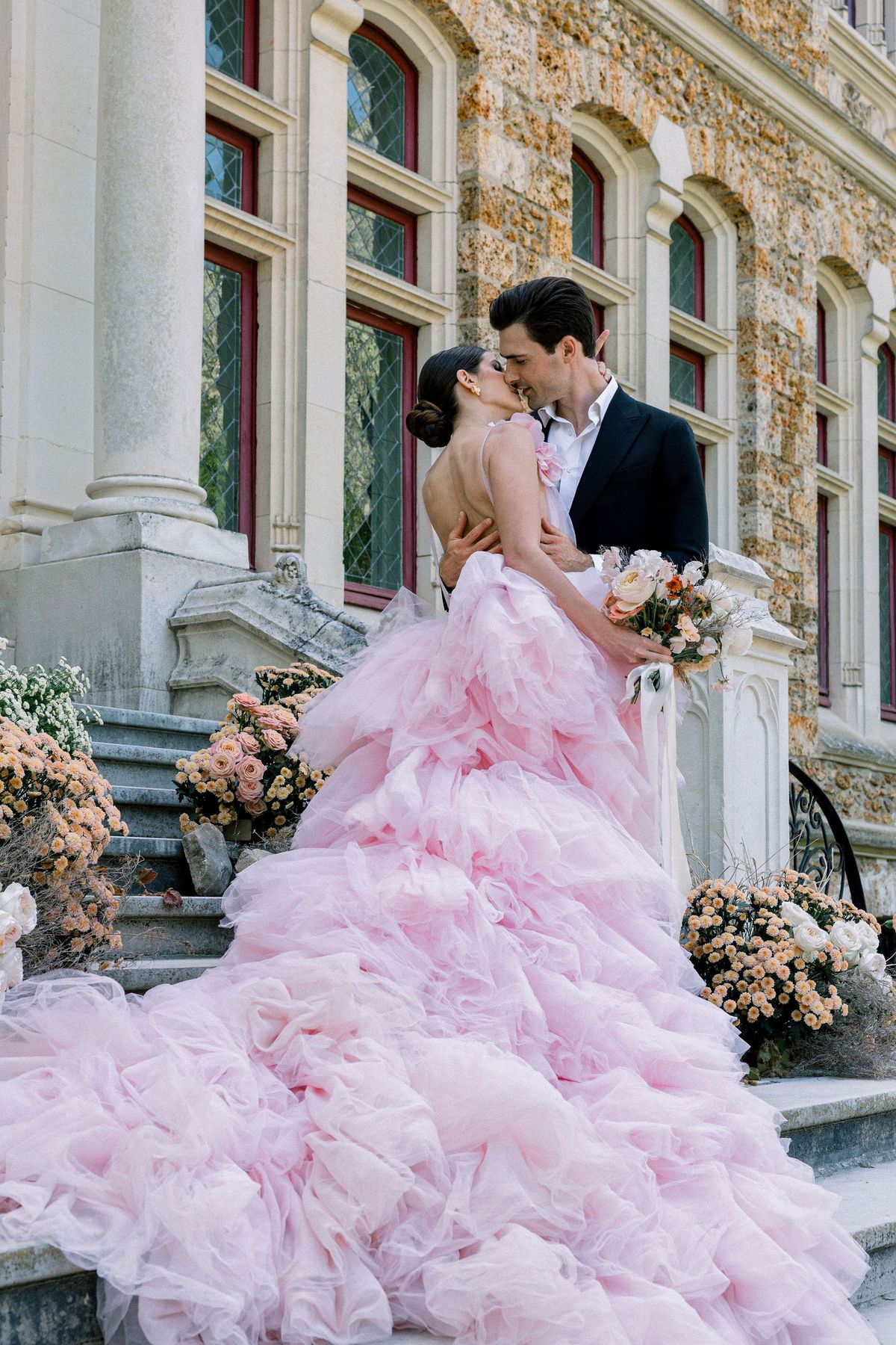 Couple kissing in pink Millia London gown at Château de Méridon, Île-de-France