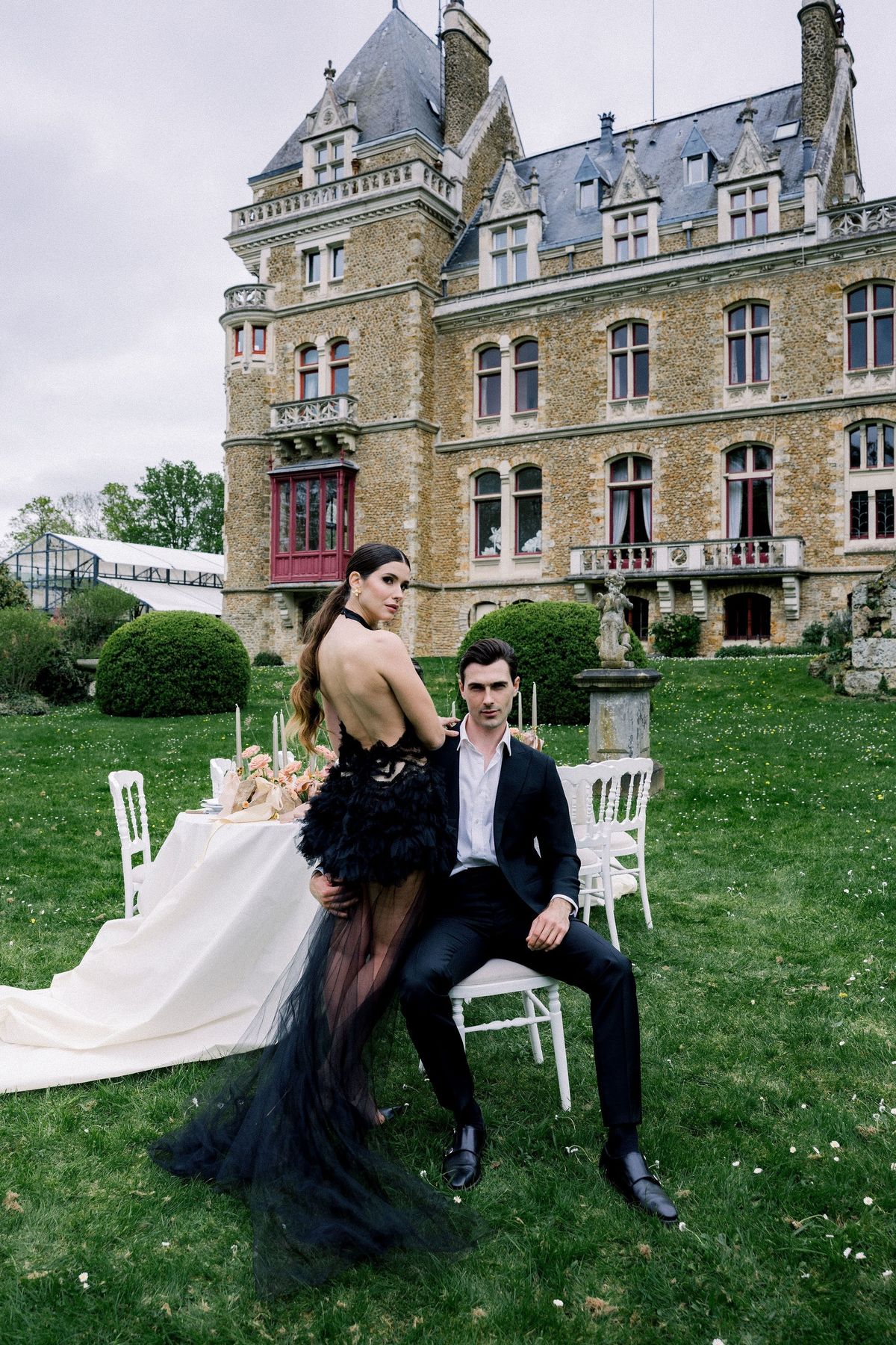Couple in black feather evening look at Château de Méridon, Île-de-France