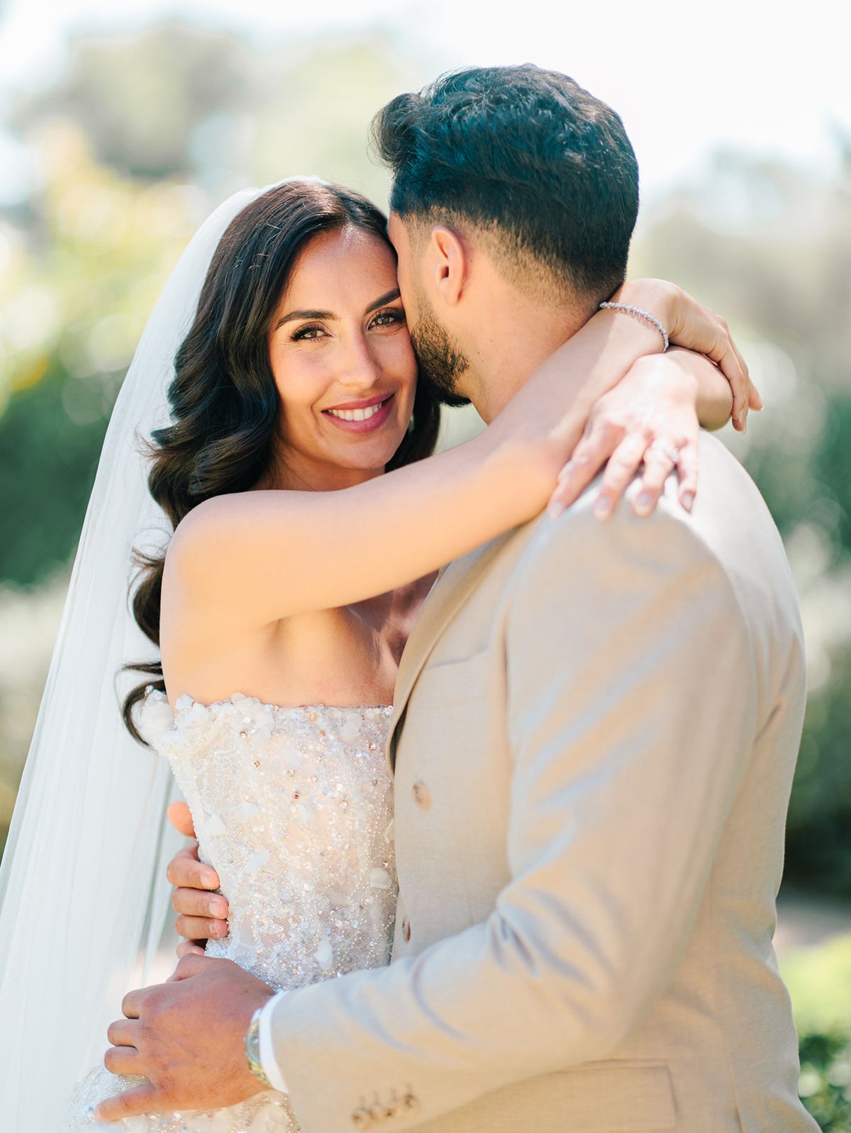 Bride and groom embracing beneath her veil