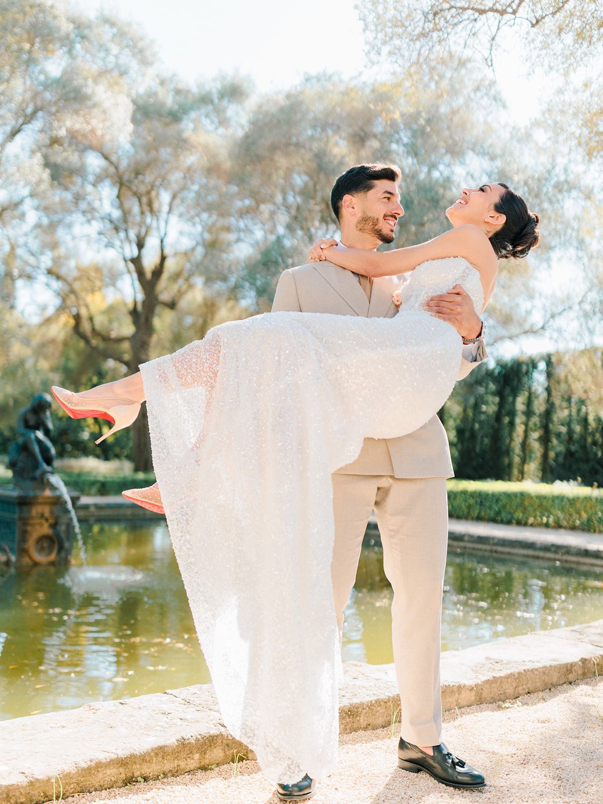 Groom carrying the bride beside the reflecting pool
