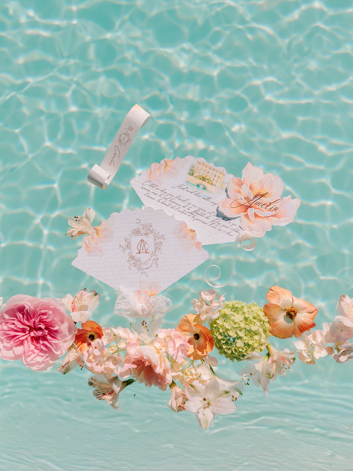 Invitation suite floating on the pool surface with peach and pink blooms
