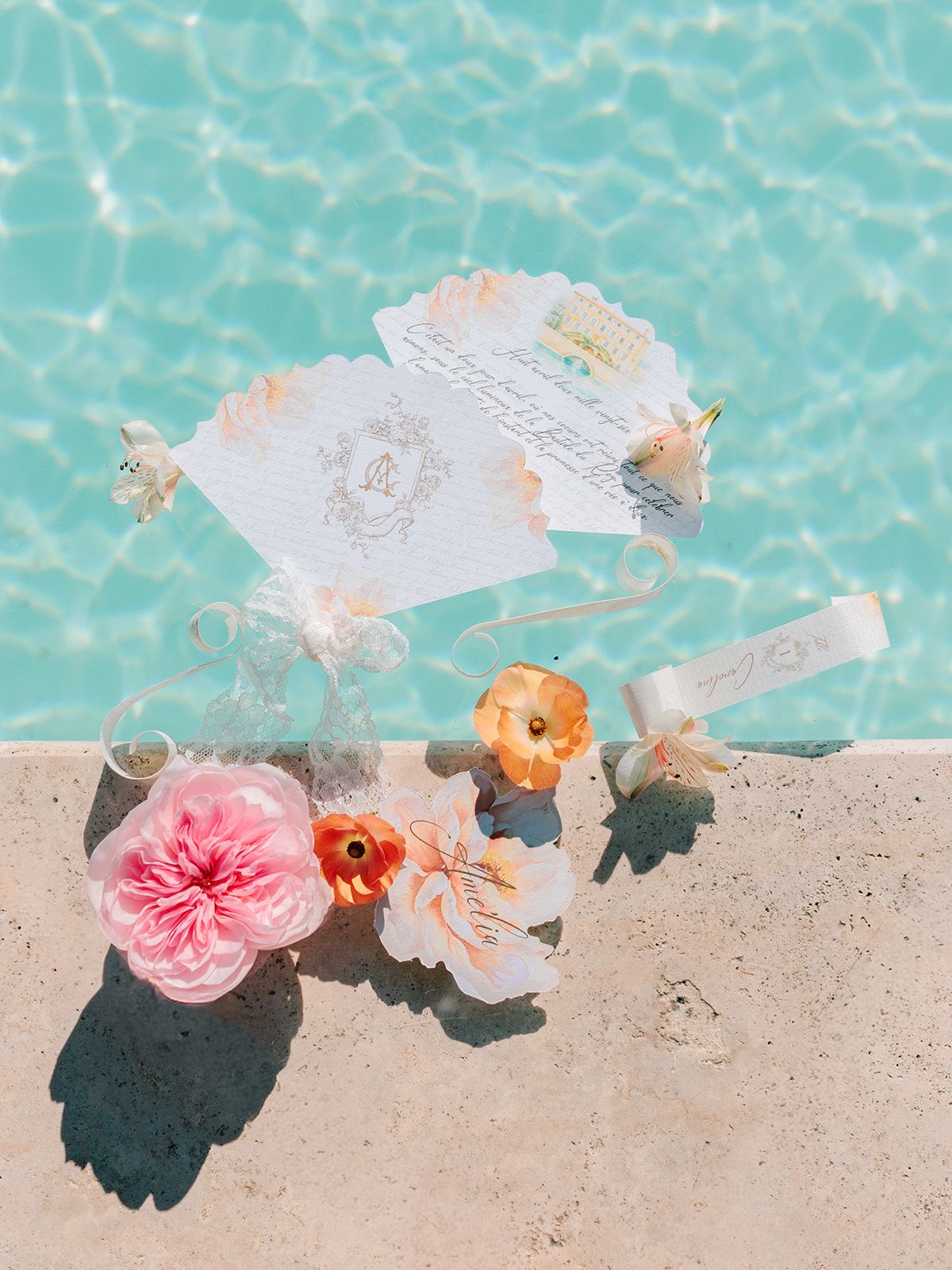 Stationery and blooms floating on the turquoise pool
