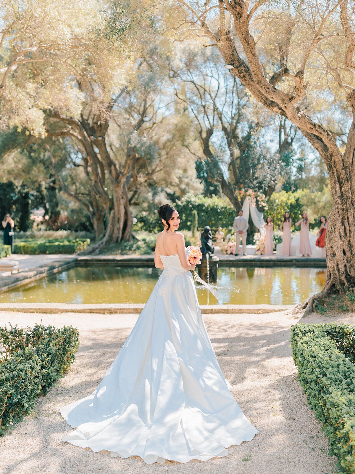 Bride walking the formal garden beside the reflecting pool