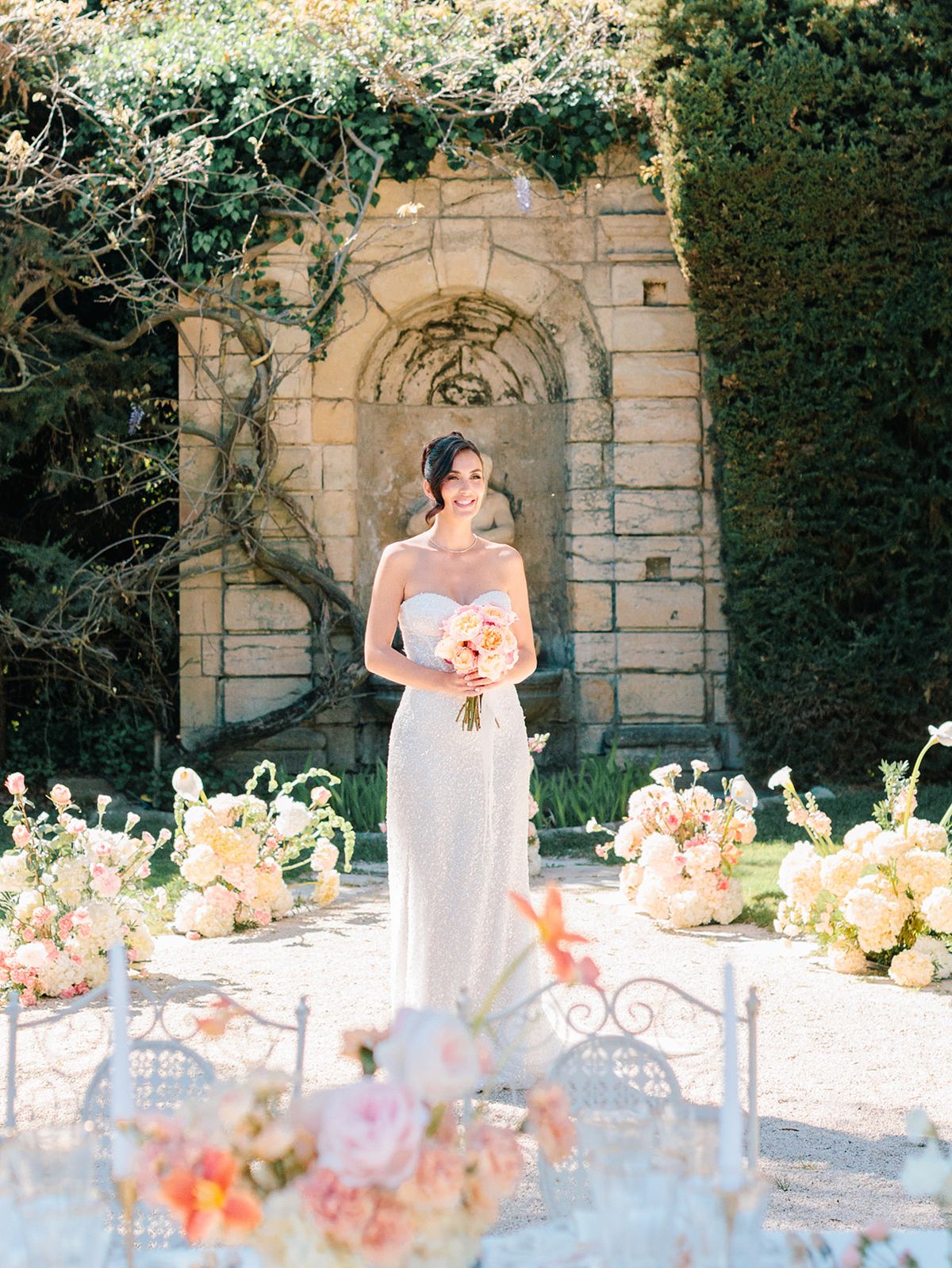 Bride with her bouquet before the stone fountain