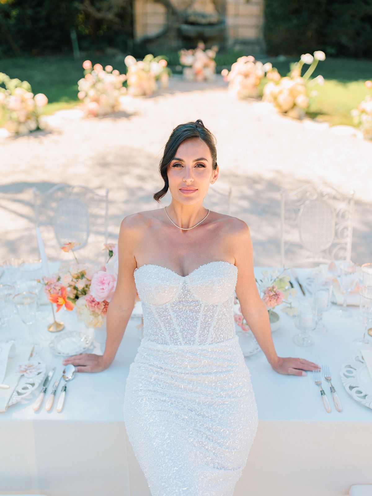 Bride in her corseted gown beside the table