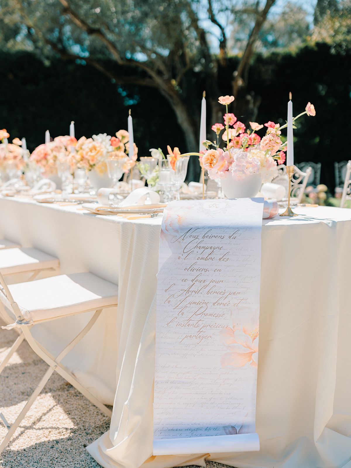 Long table laid with menus, candles and blooms
