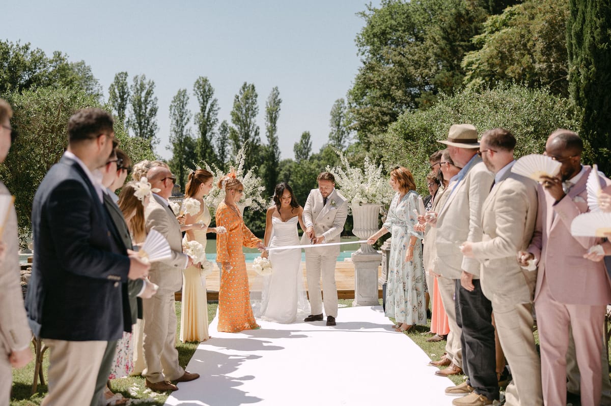 Newlyweds walking through cheering guests after the ceremony