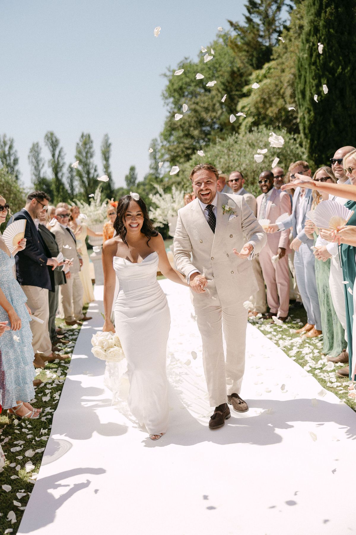 Bride and groom laughing under a shower of confetti