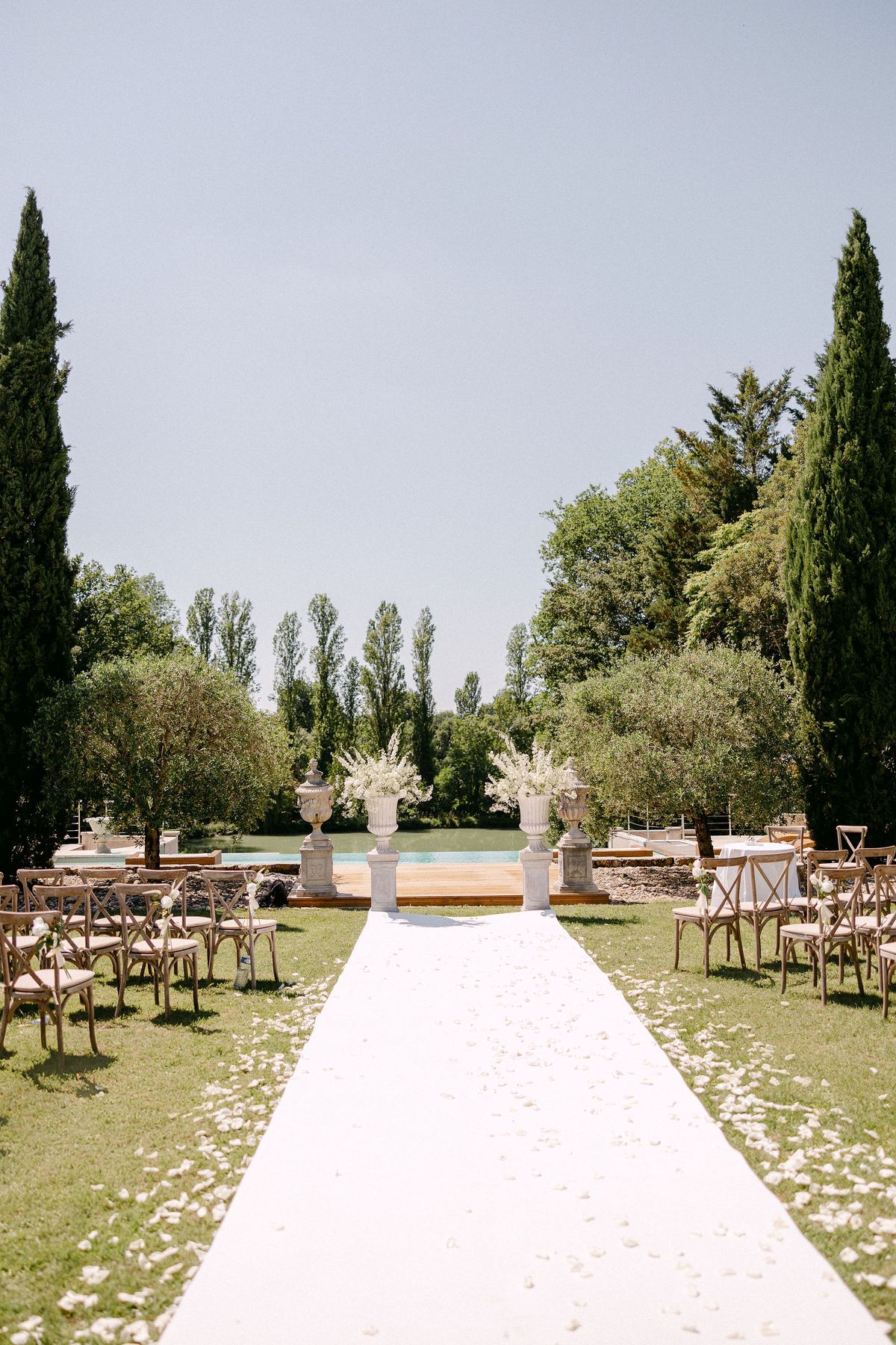 Empty ceremony aisle set with white floral urns