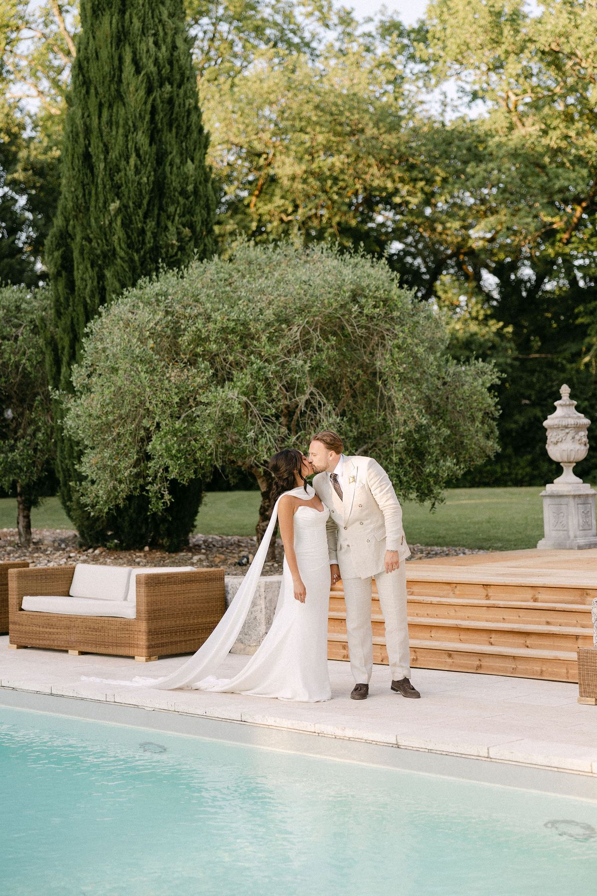 Couple sharing a kiss on an outdoor lounge sofa